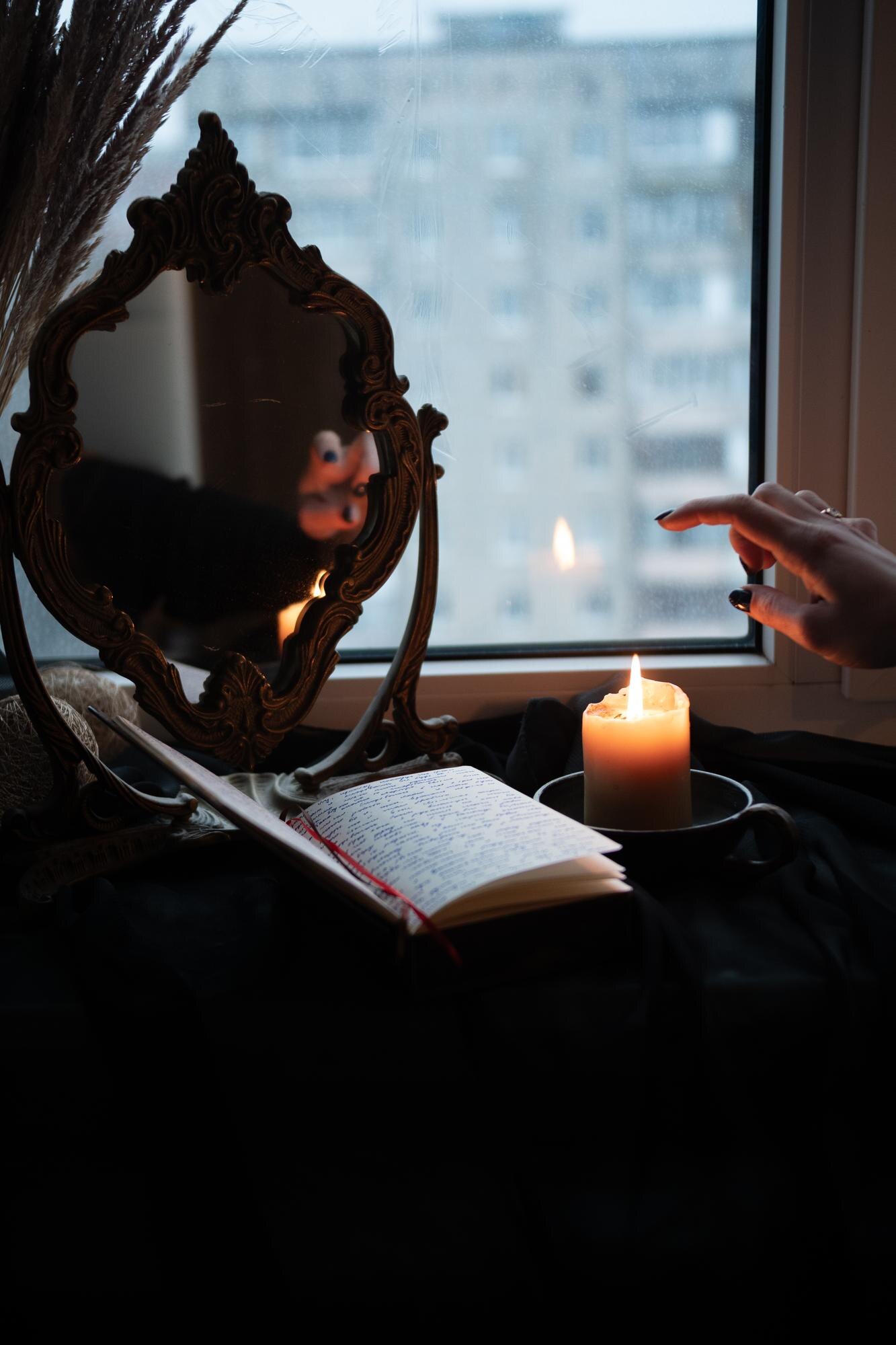 a candle and a book by the window 3568bd63a0943a5b32d3