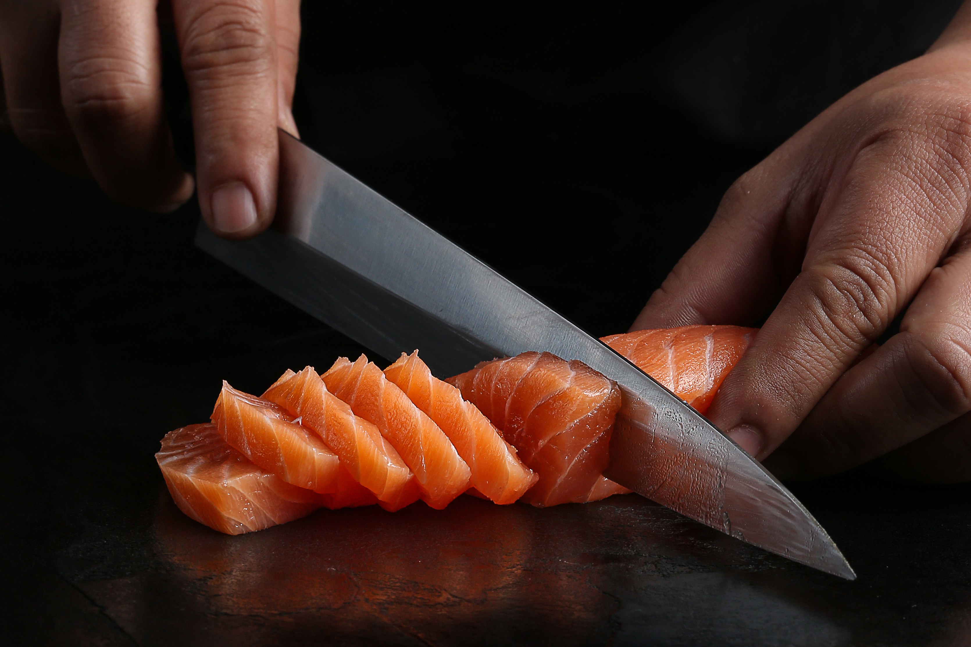 a chef slicing fresh salmon fillet with a sharp ja 1dcaf21dbc7f16e69802
