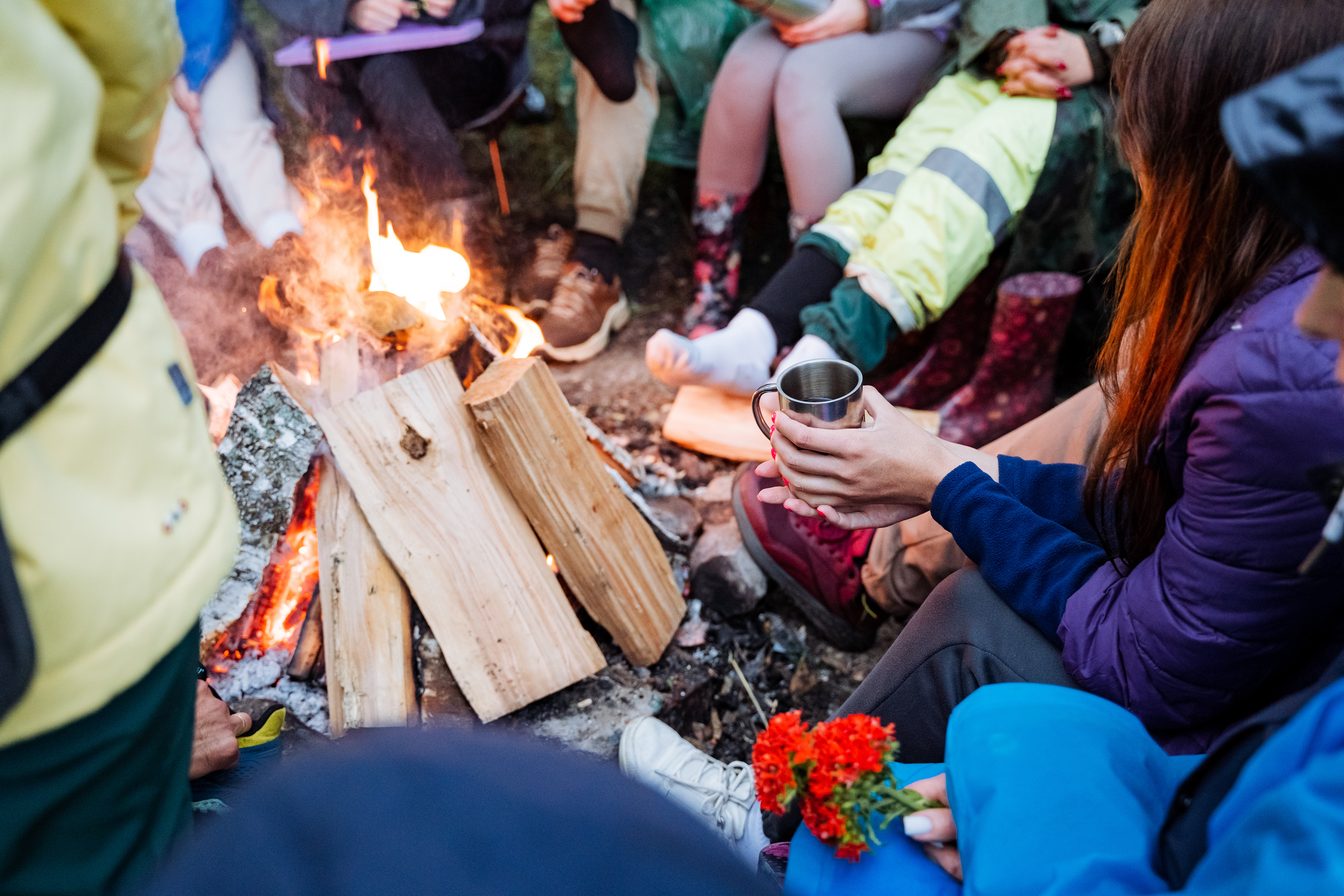 a diverse group of friends gather around a campfir 337e23d2c53f6c62442f