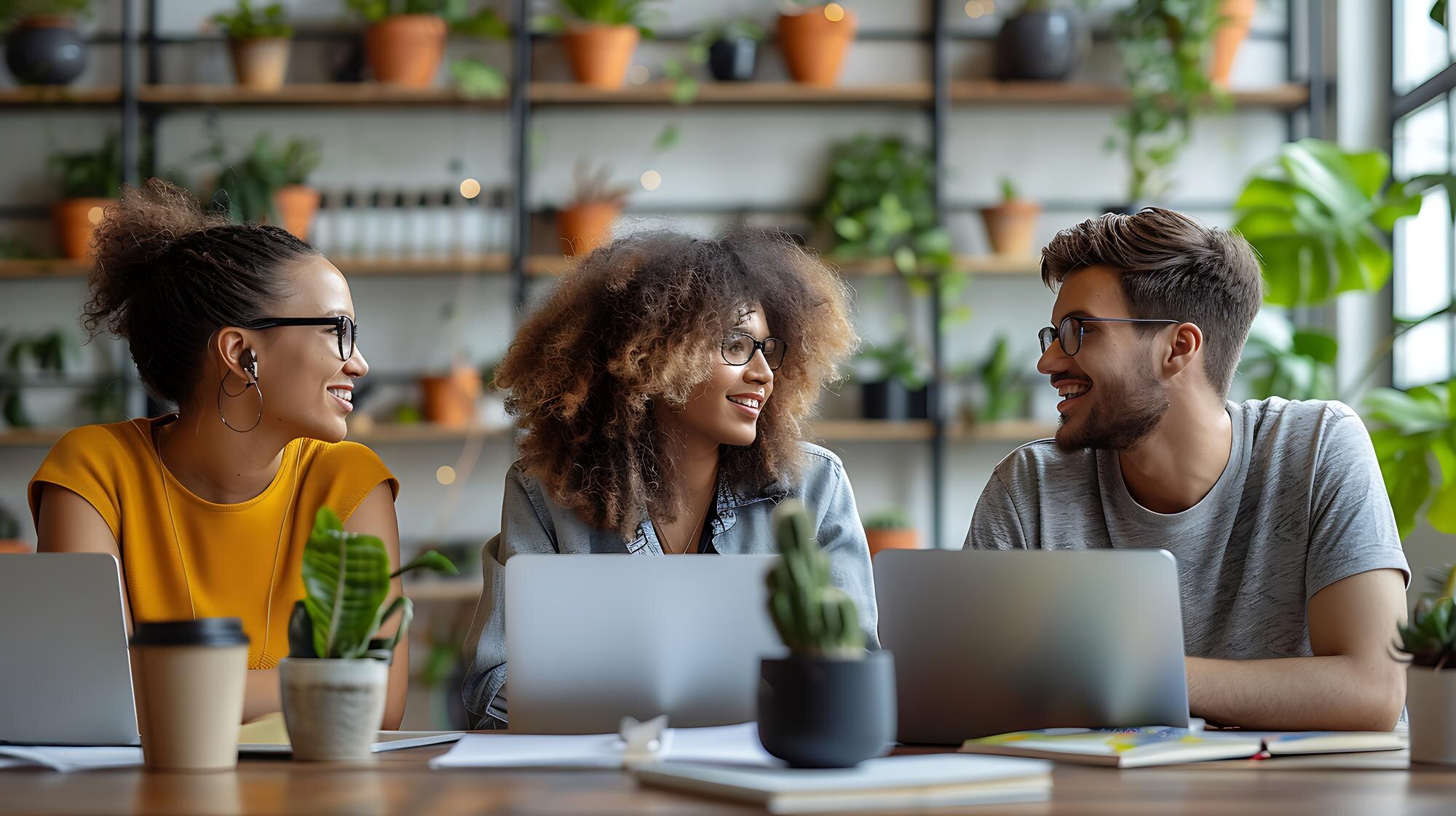 a group of people sit at a table with laptops and 3a2f8ba9a22dbed1e786