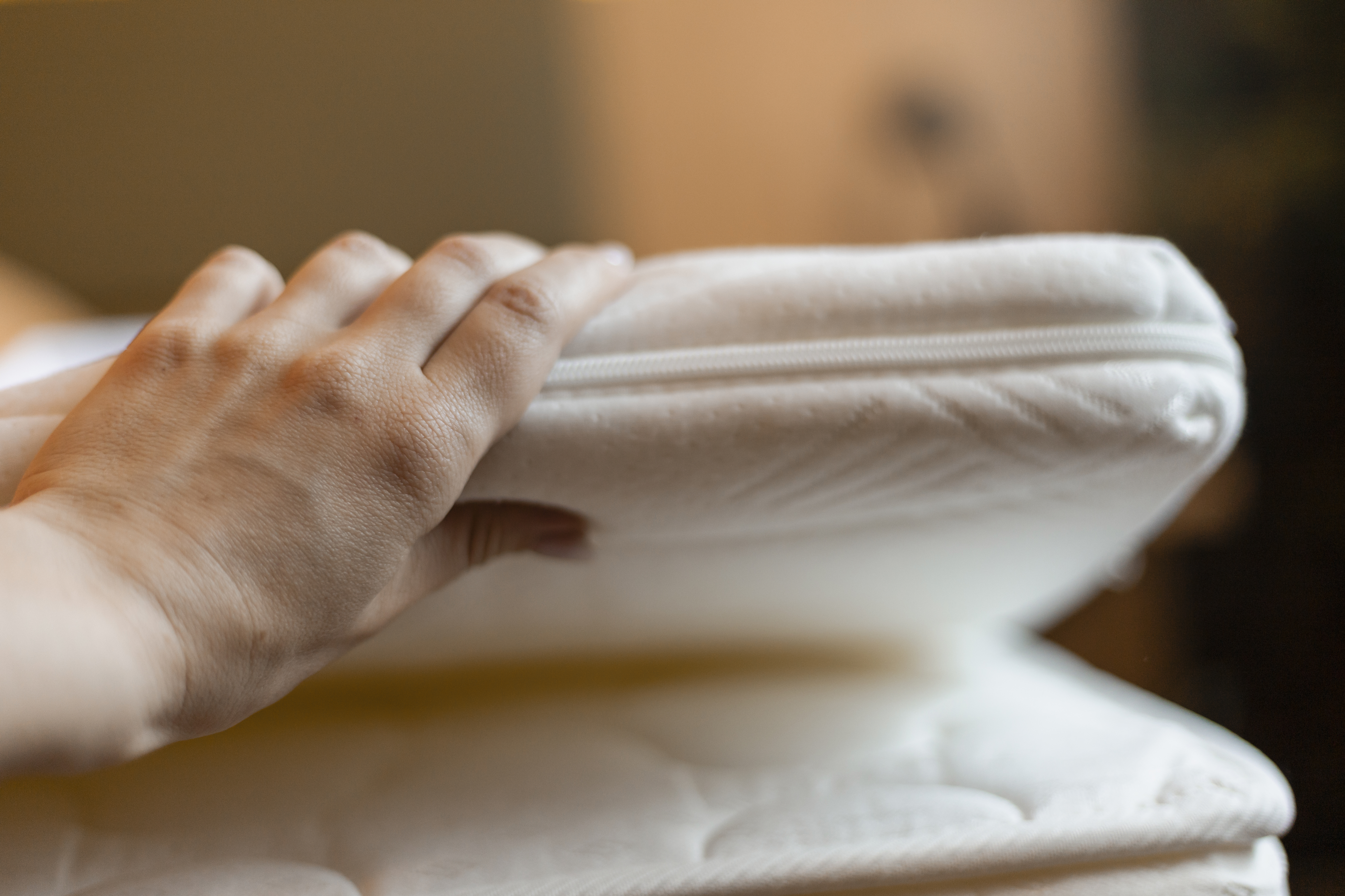 a hand places a plush mattress topper on a bed en dc144c8038df2a1f33e2