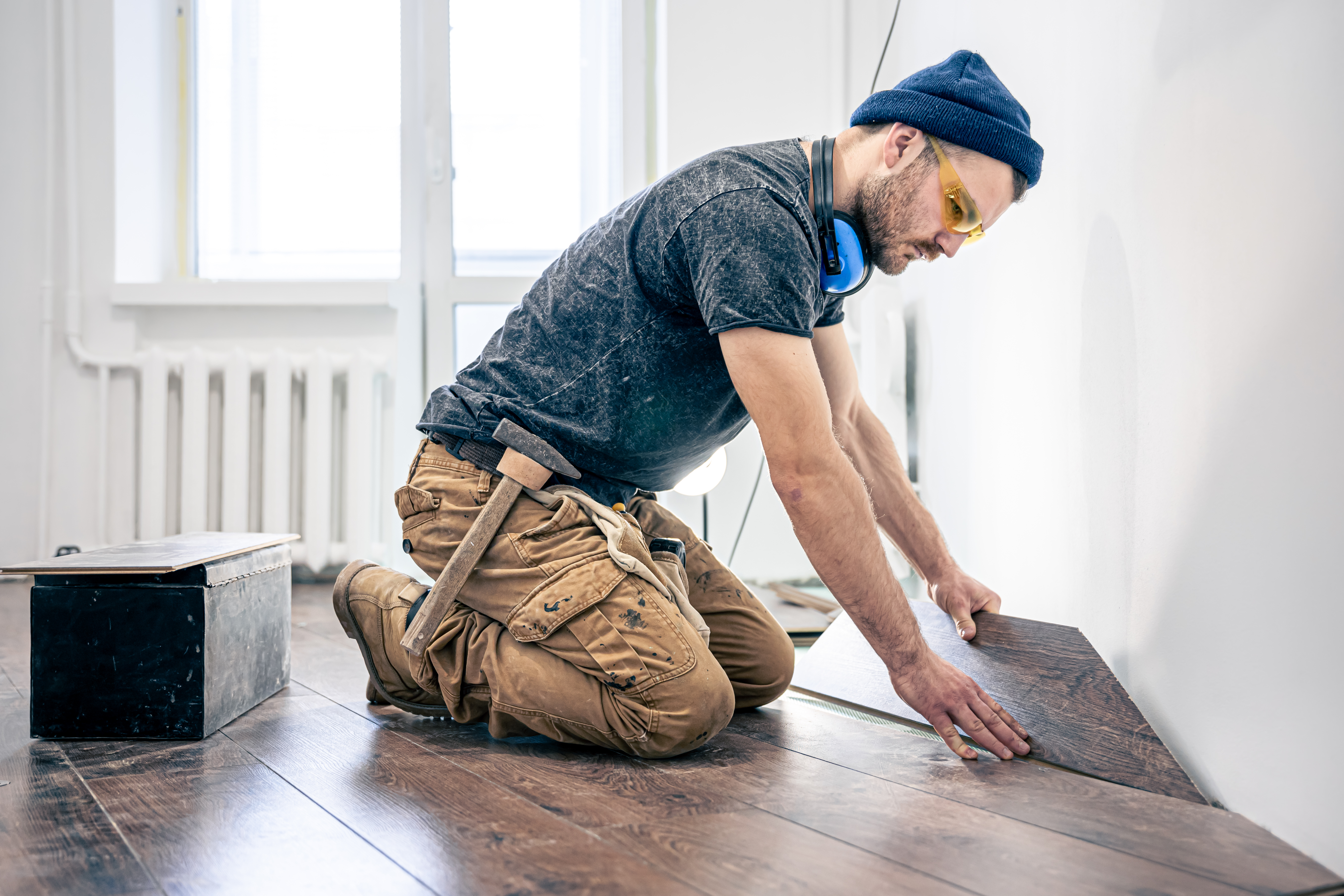 A male worker puts laminate flooring on the floor e763ac3e0c040afbc0e3