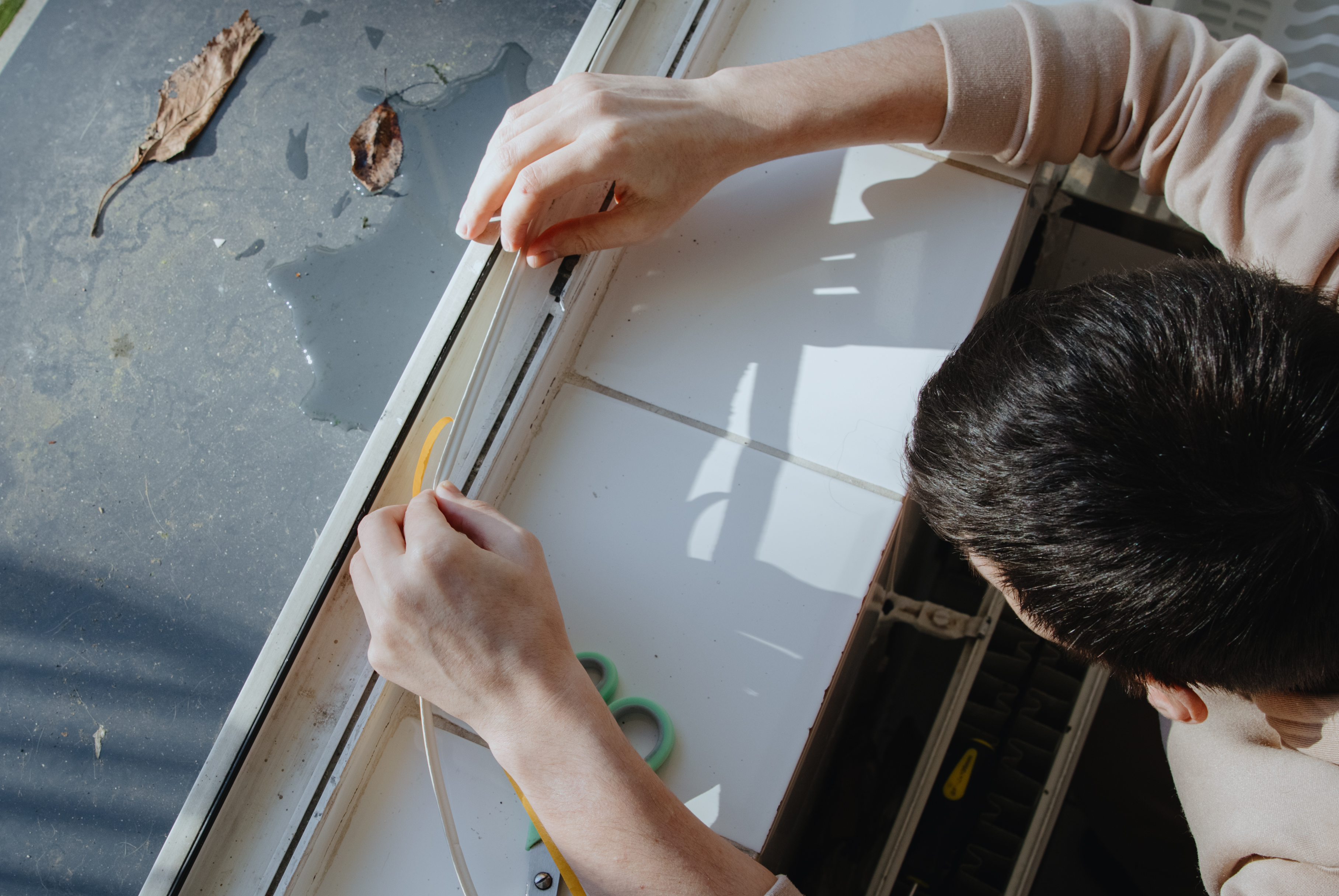 Why Local Know‑How Matters in Complex Plastic Fabrication 3 a man insulates a window frame with a rubber profi c5771b246ecf502a7577