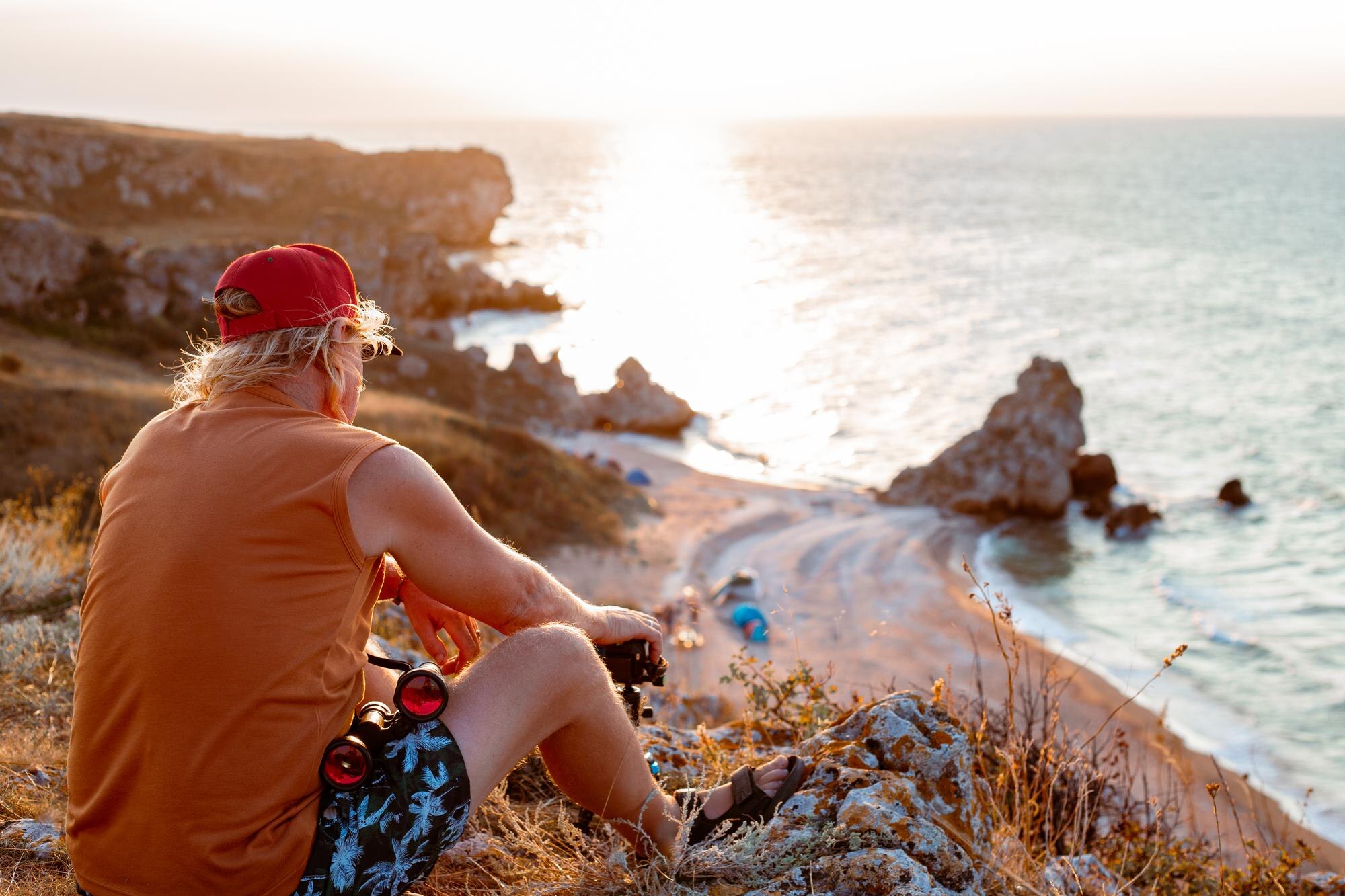 a man sits on top of a mountain and sets up a came 741c4a5326bac62ca8be BTOURS