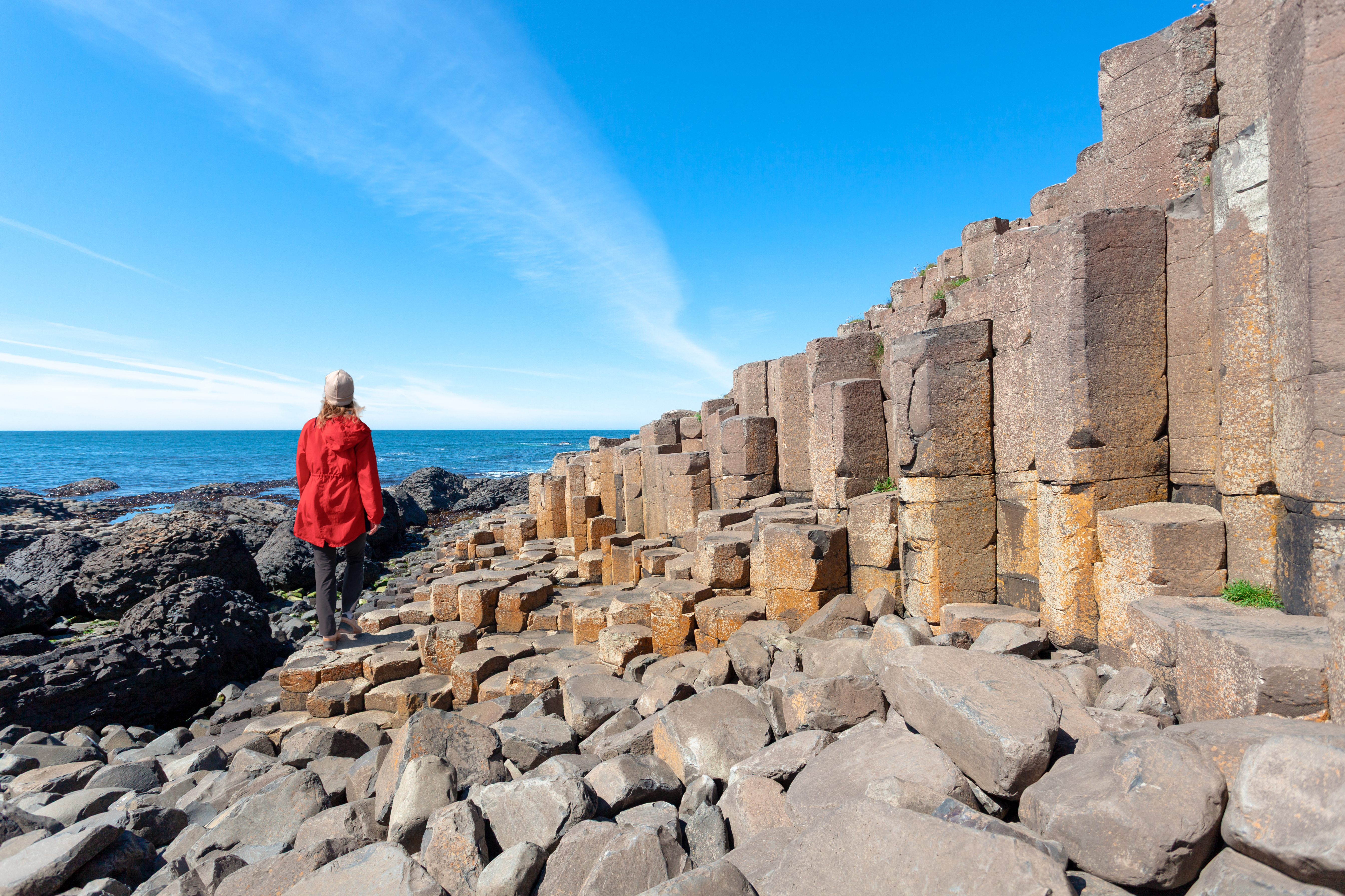 a person in a bright red jacket walking along the 39db42abb41626c1c5e6 BTOURS