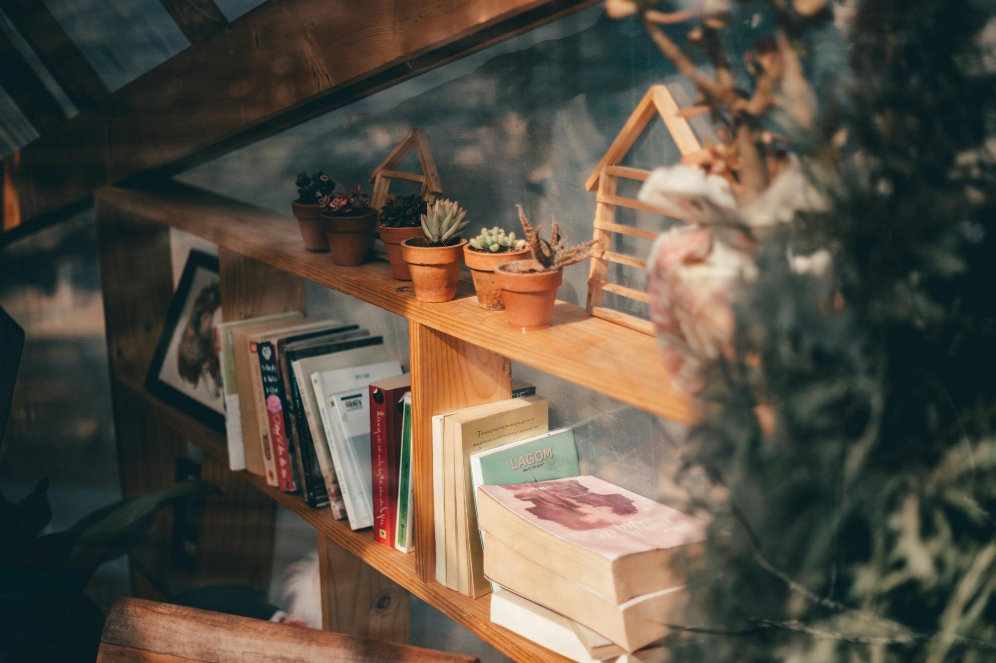 a shelf with a book shelf with a plant and a book de5ec10f6e58188b499d