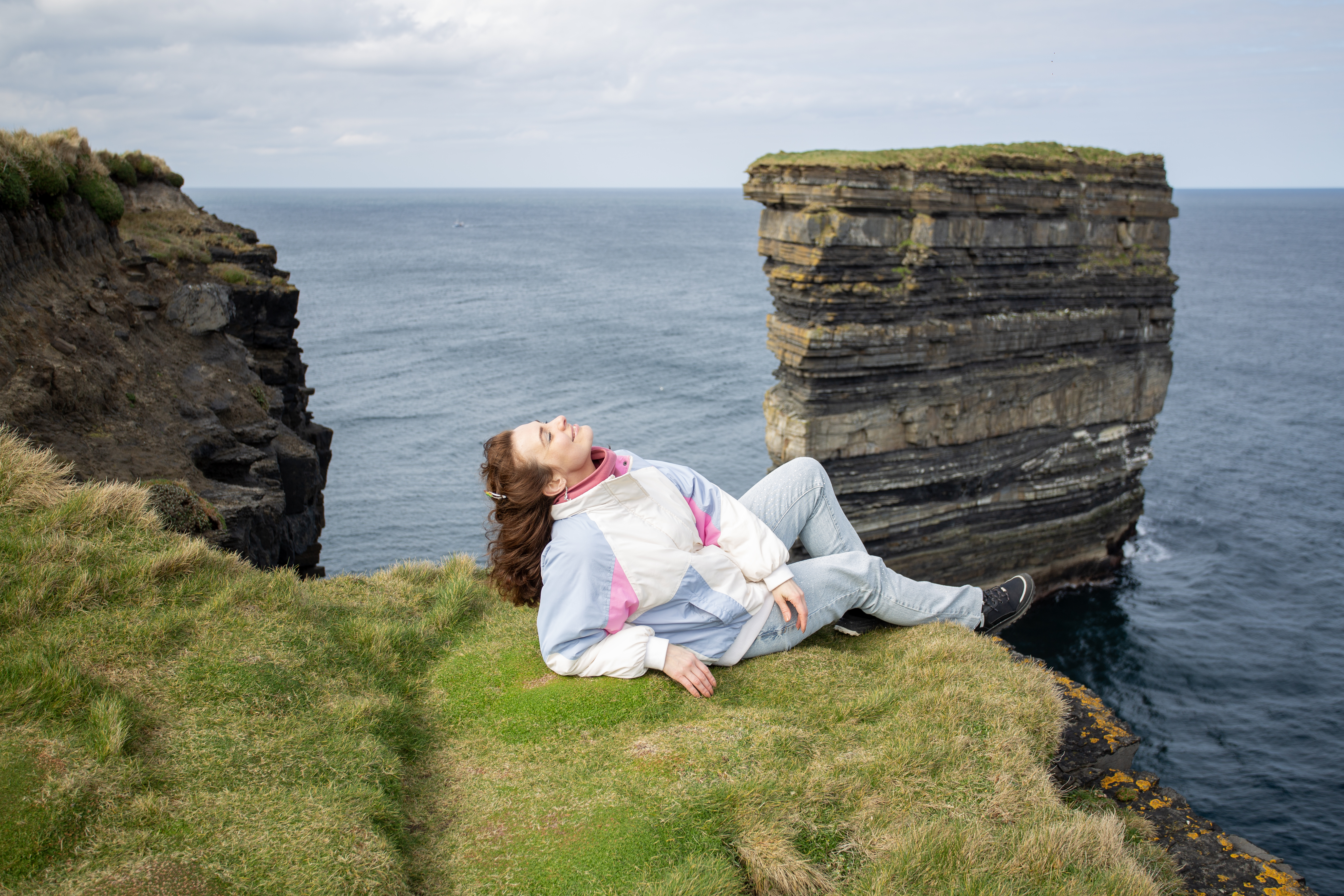 Slow Roads, Secret Ireland: A Self‑Drive Guide to Hidden Gems 4 a woman enjoying a relaxing moment on a coastal cl 96e8fdeef80c650f2b1b BTOURS