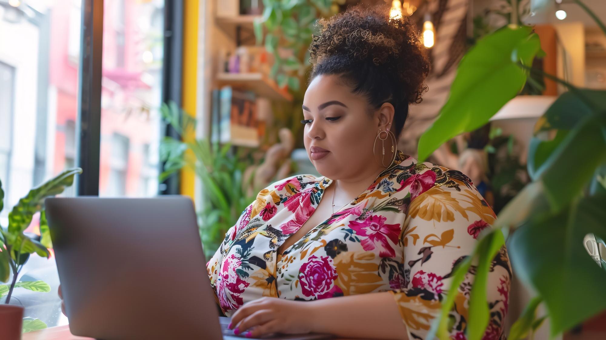 a woman using a laptop with a floral print shirt o 7c73b58f89c1da5d5206