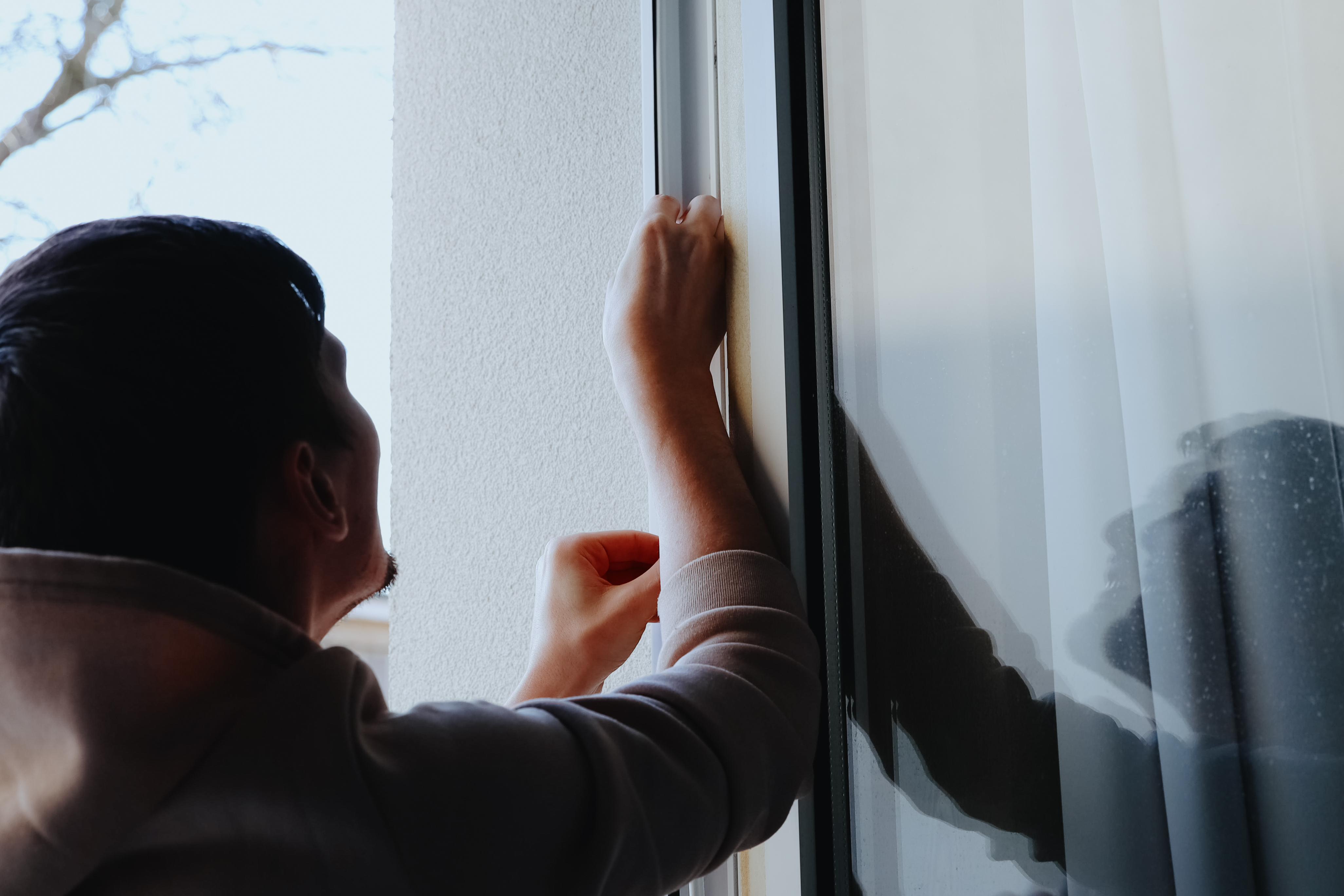 Why Local Know‑How Matters in Complex Plastic Fabrication 2 a young guy is manually insulating a window frame a91e0bf3a3f3dfca278a