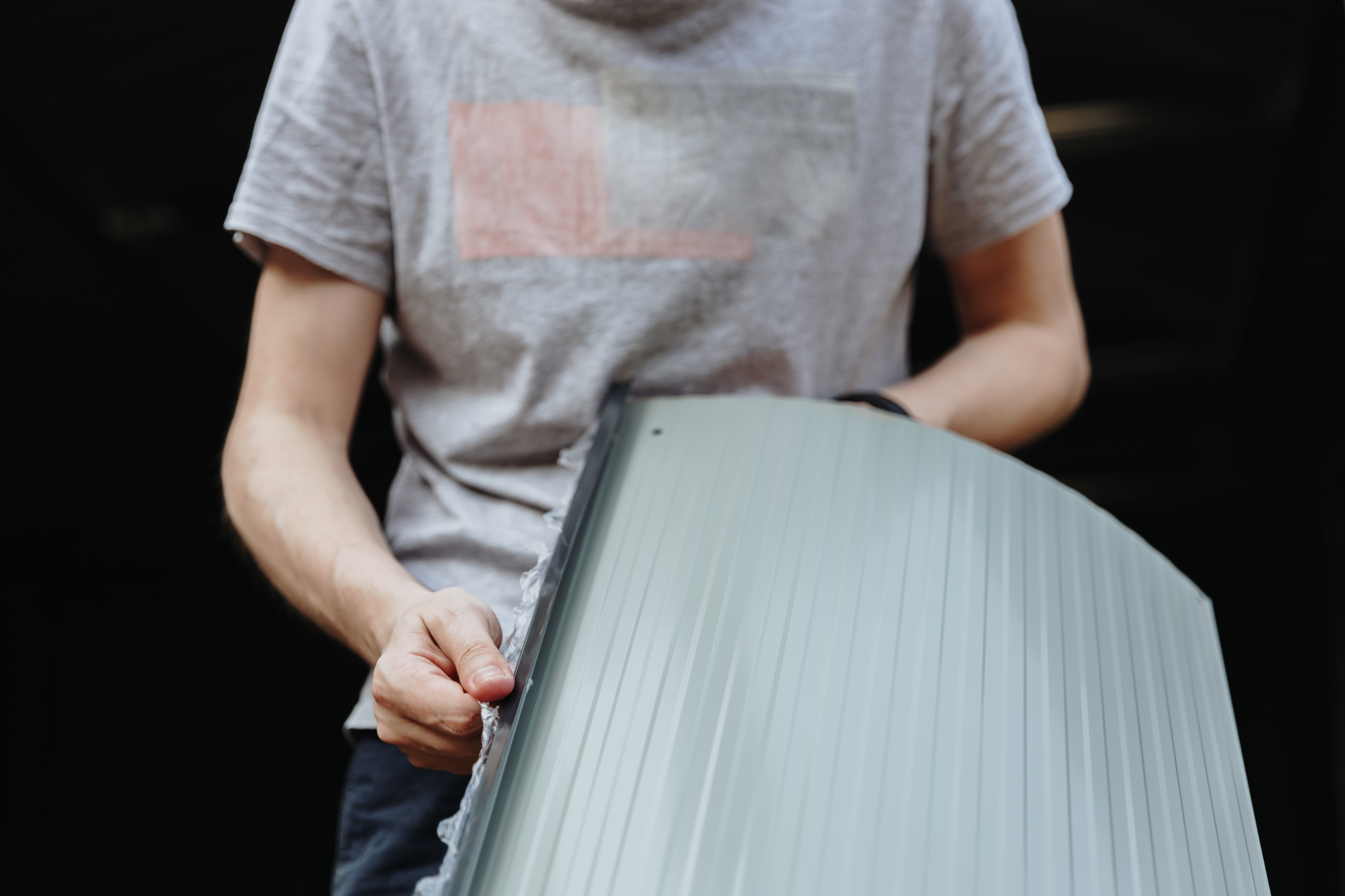 Preventing Warping and Cracking in Plastic Sheets: Practical Tips for DIY and Trade 3 a young man removes a protective film from a metal 49fc0f694fa011168d41