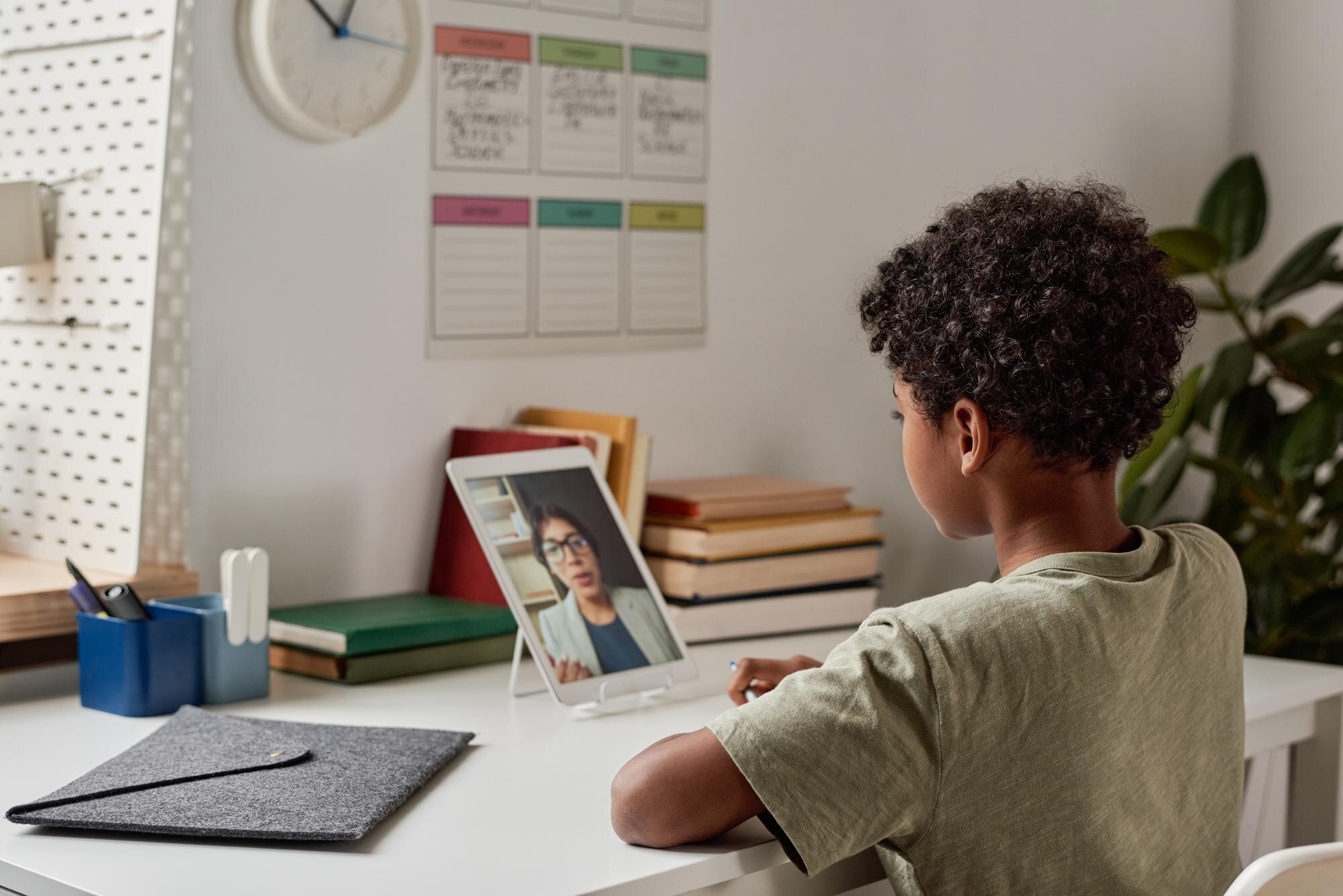 African American Biy With Curly Hair Sitting At Ta F4c06ff9f4c6deb387ae