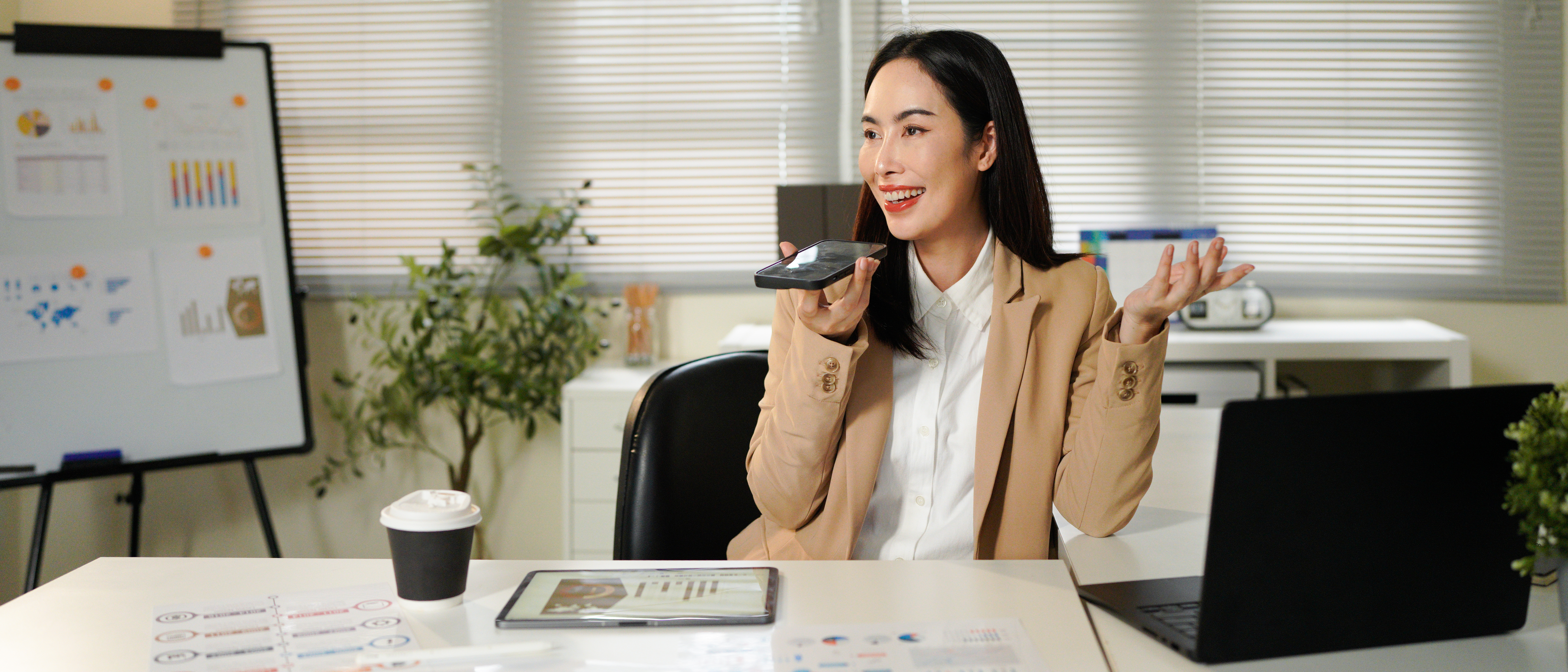 asian businesswoman in a beige suit talking to voi 33037356c13413bc3a9f