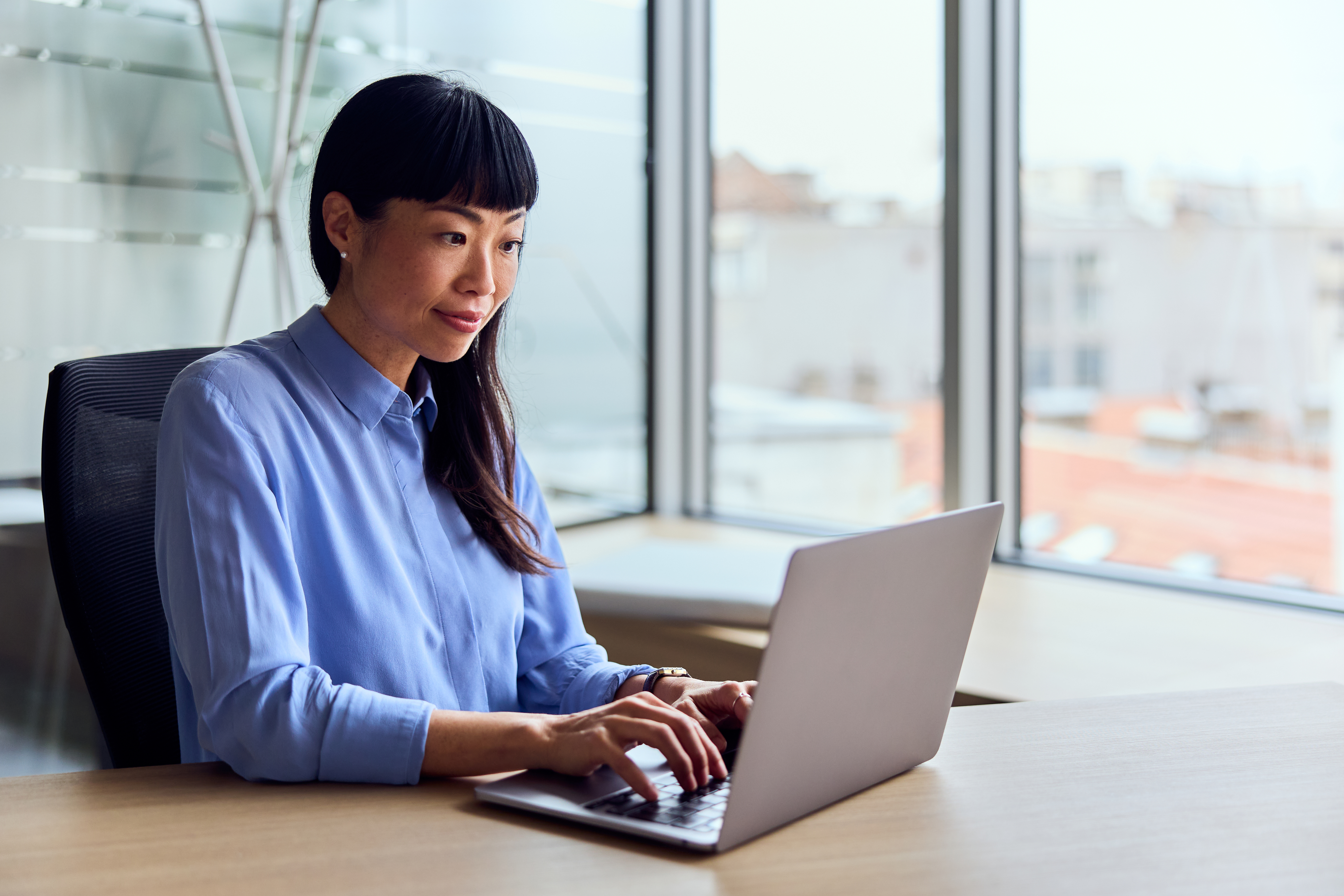 asian woman working on laptop at a modern office d edfebccbbb6fa618af08
