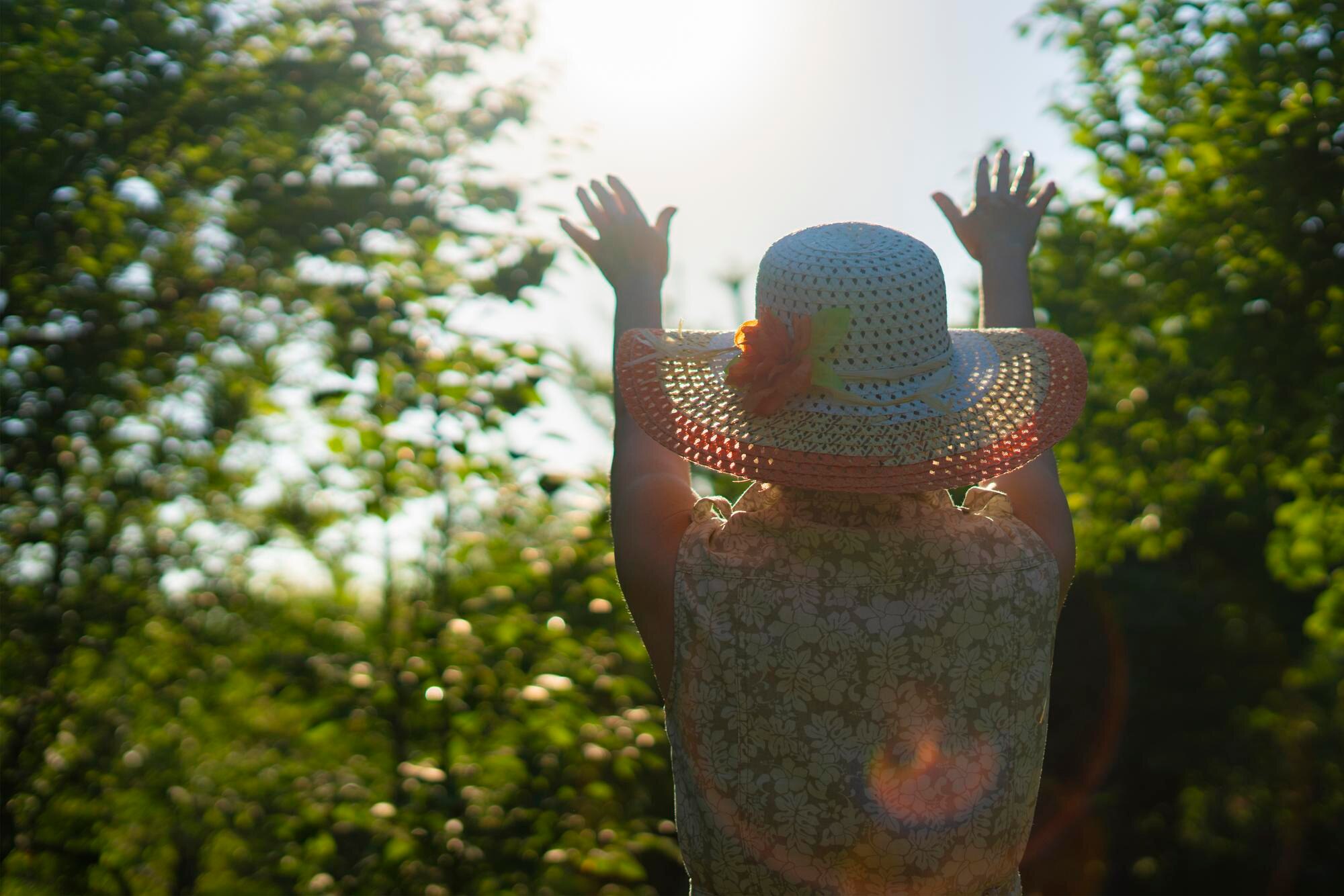 back view of adult woman in summer hat raise hands 945ead0baf6a85500239