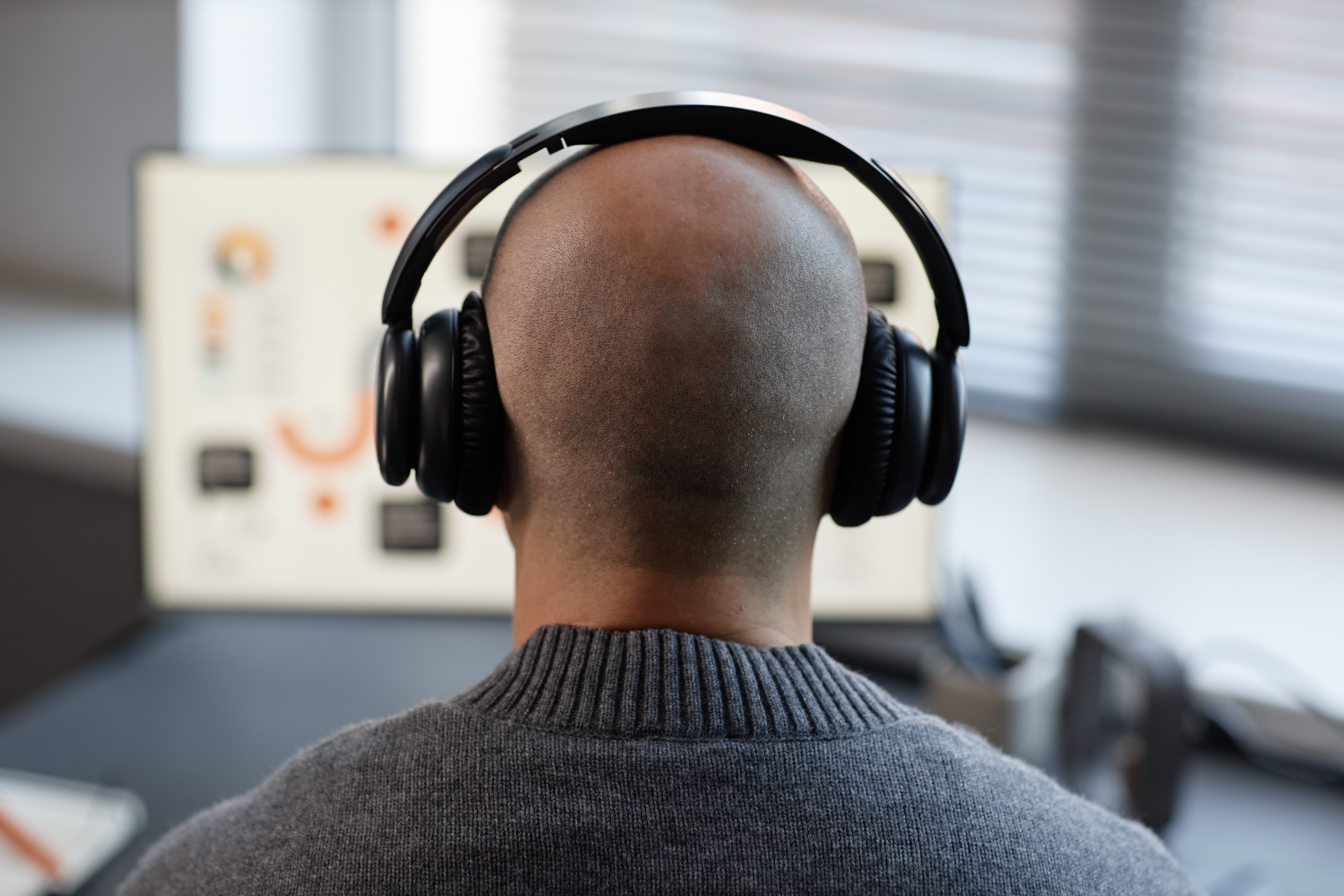 bald man listening to music wearing headphones whi 04240b51aa88fe3e1f99