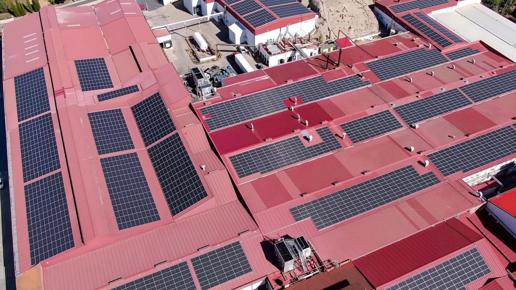 Warehouse building with solar panels installed on a newly replaced roof for commercial property owners.
