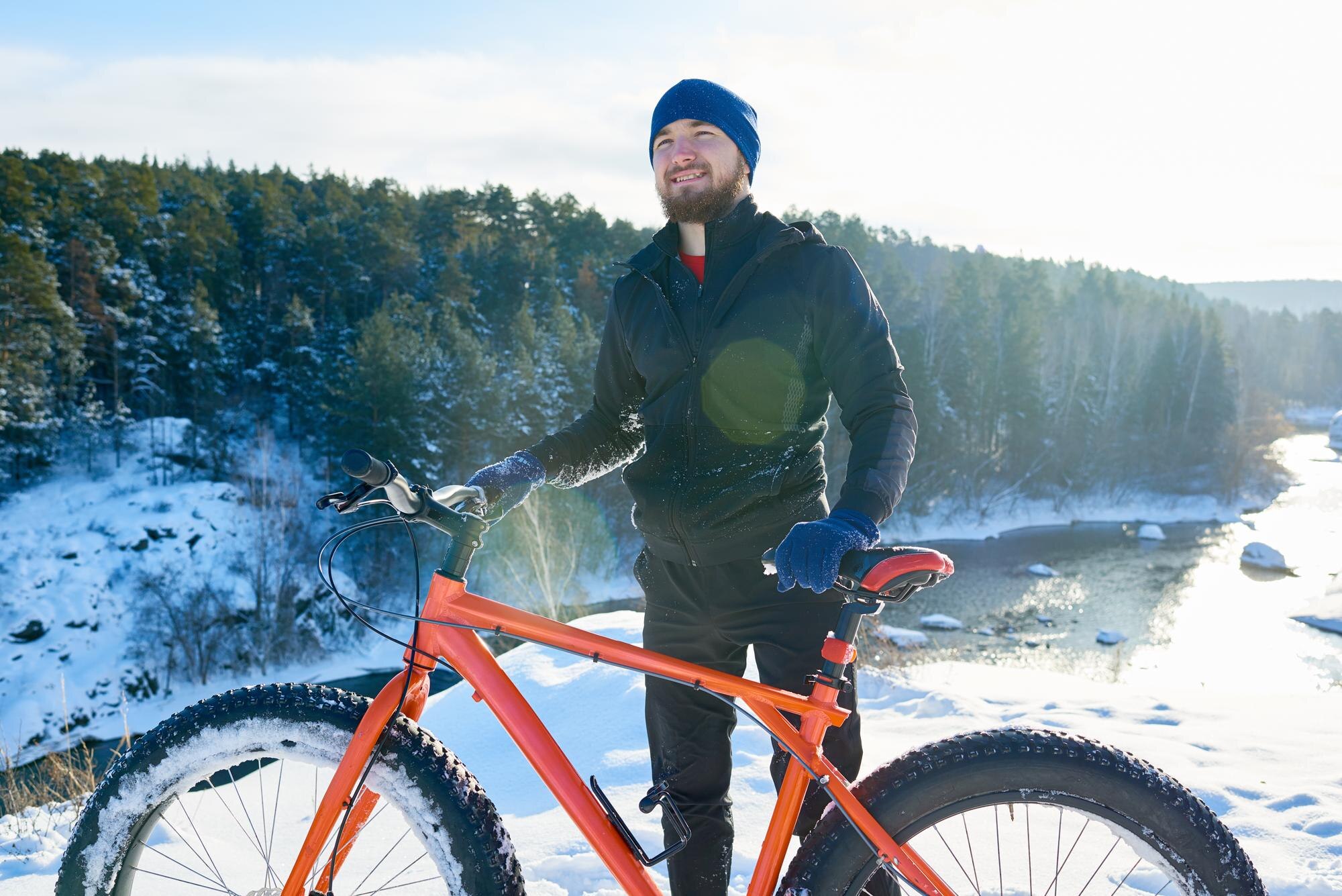 Cycliste en hiver devant la foret