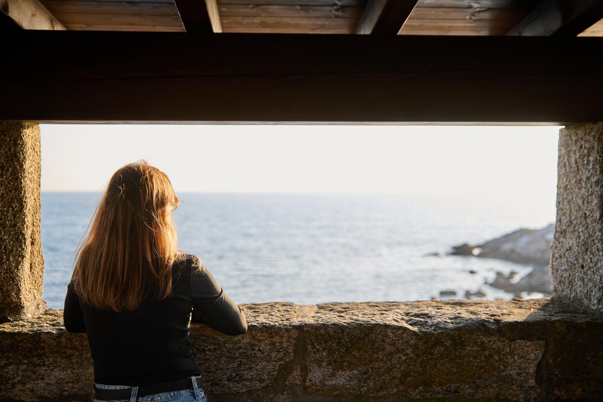 blonde woman looking at the horizon from a stone w 25c2575e67149a9fb364 BTOURS