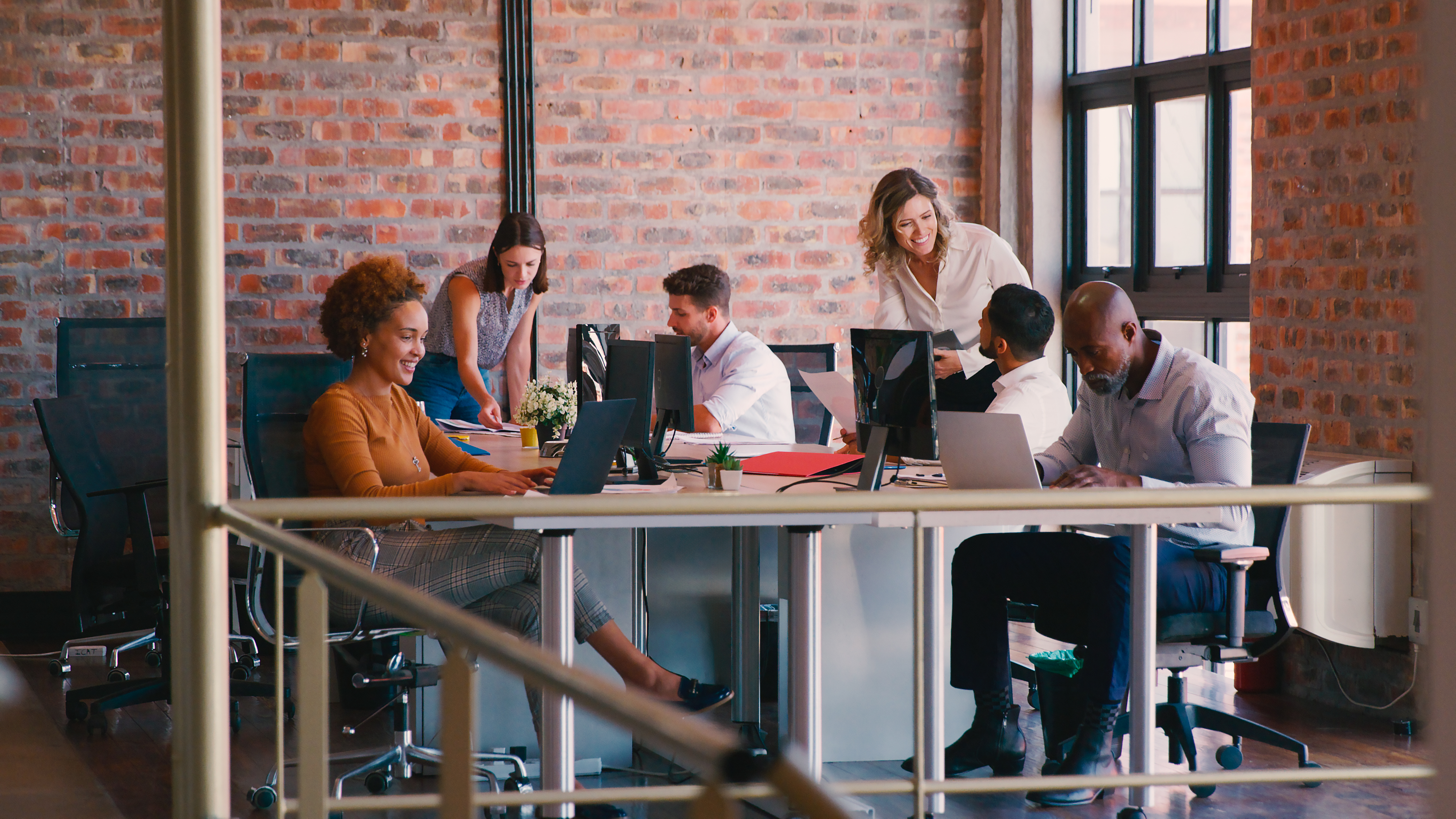 Business team collaborating at desks in a modern office, focused on effective review management strategies to enhance local SEO and online reputation.