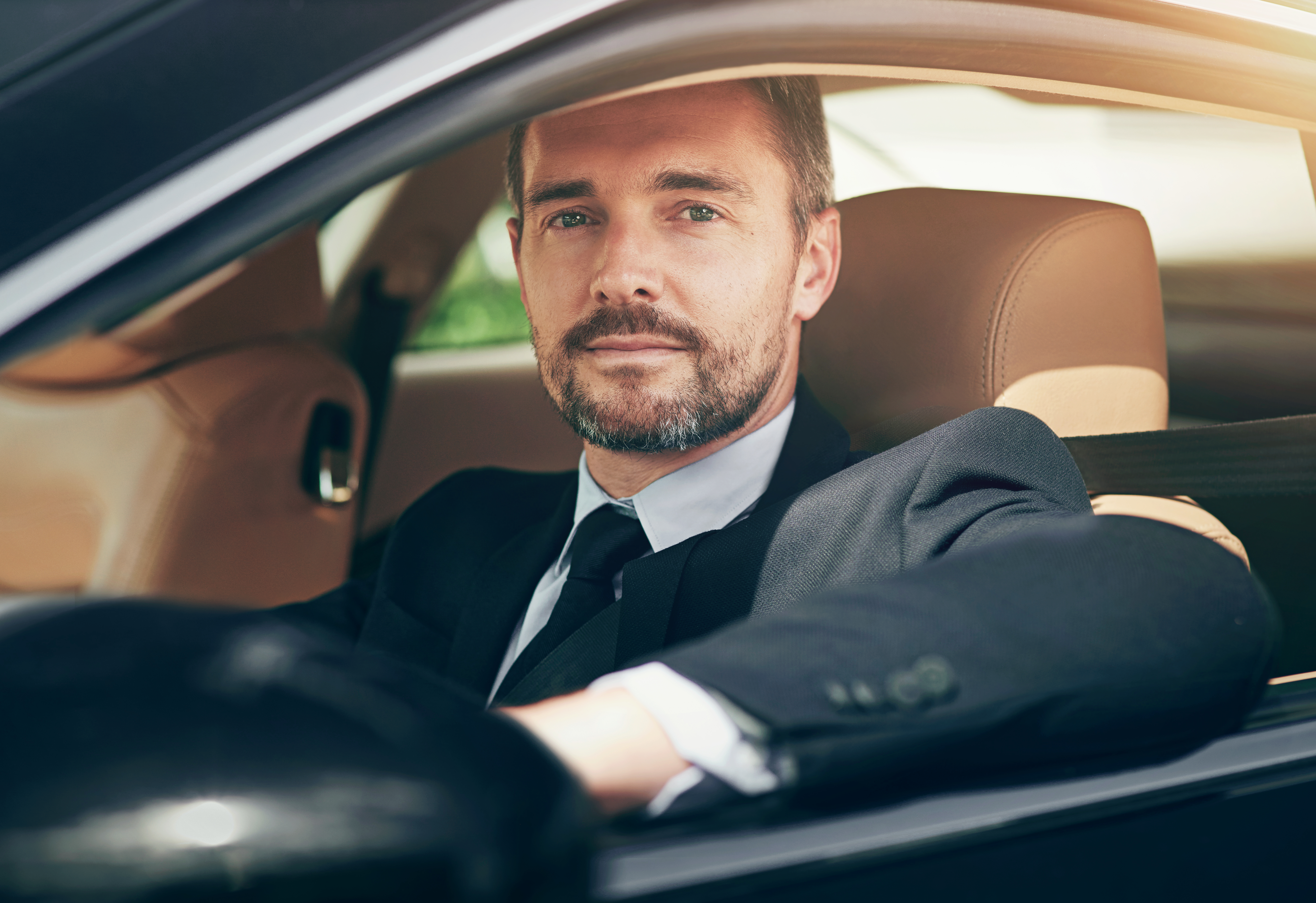 Professional chauffeur driving a client in a luxury vehicle for Mak Louren Chauffeur Service in the Boston area.