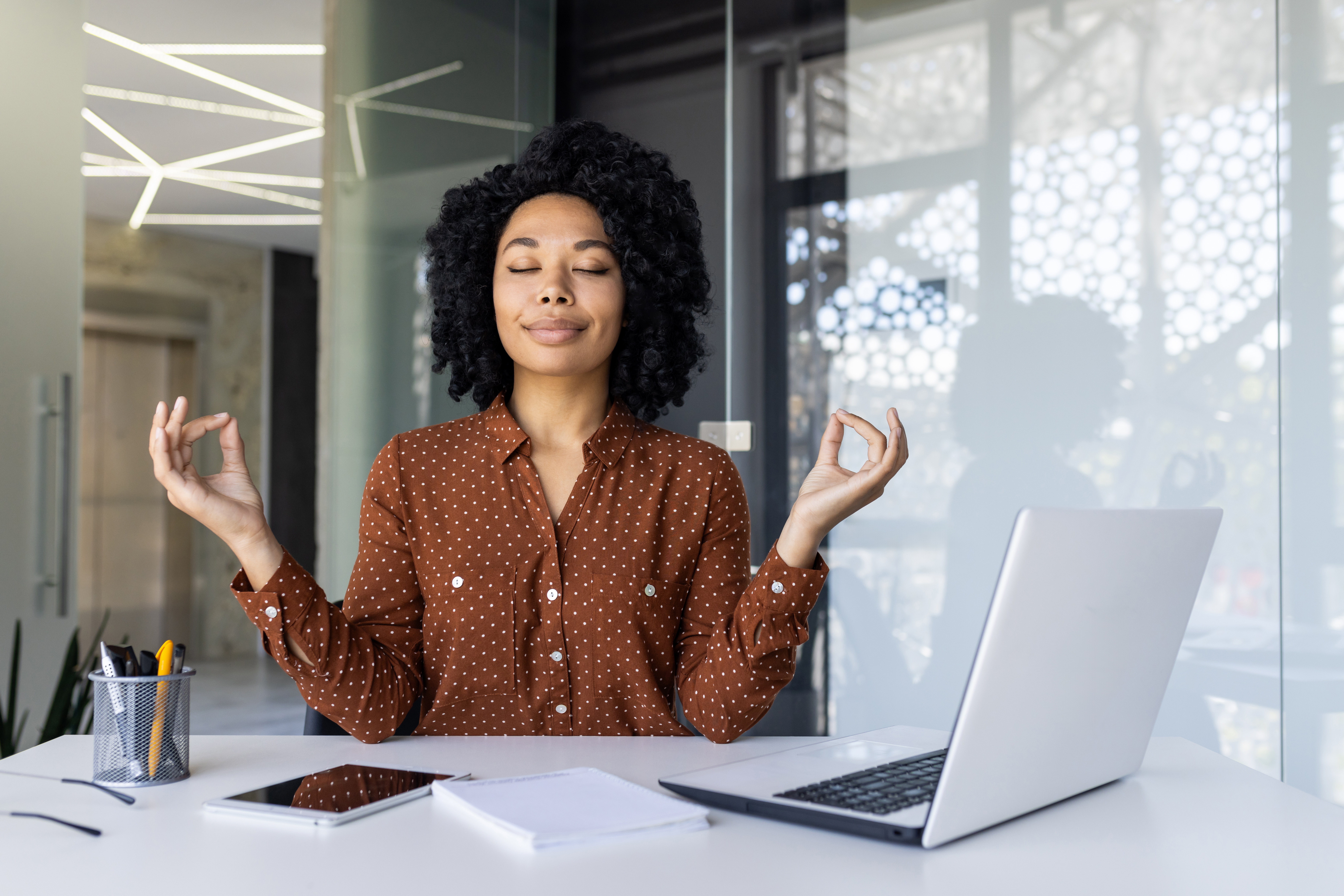businesswoman practicing meditation at her office a3e83882a8550541a37b