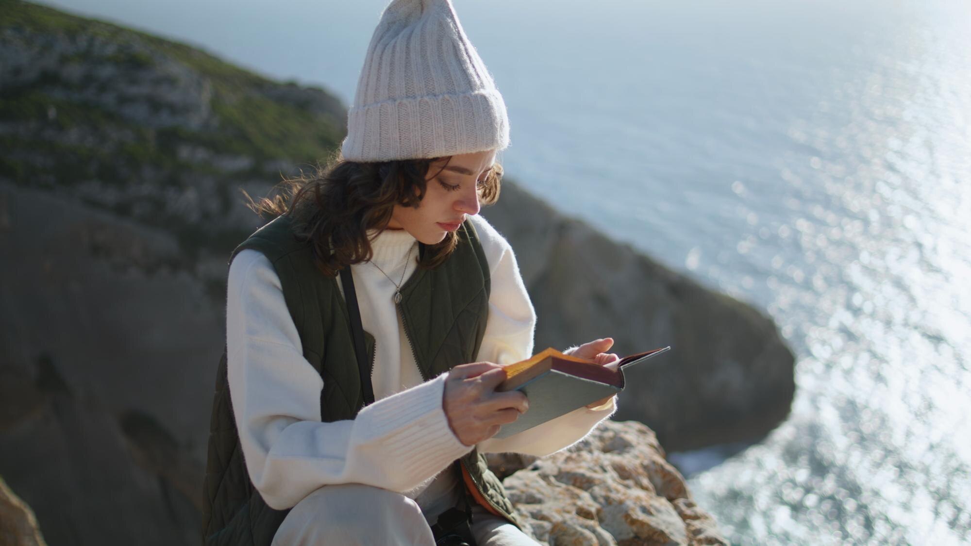 calm girl enjoying book at ocean cliff edge focuse 1821362ad2f12cc63ce2 BTOURS
