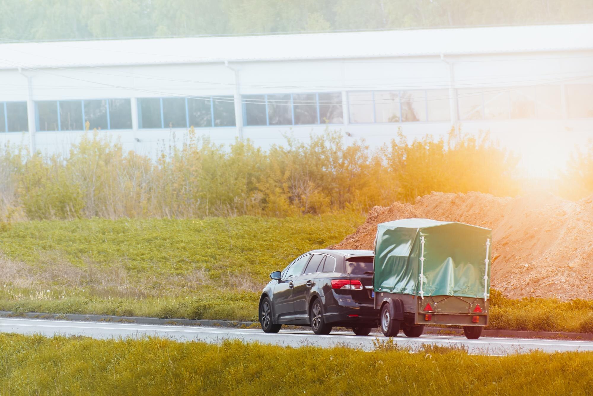 car and covered trailer driving on the road 760d41a3129319cf49ed