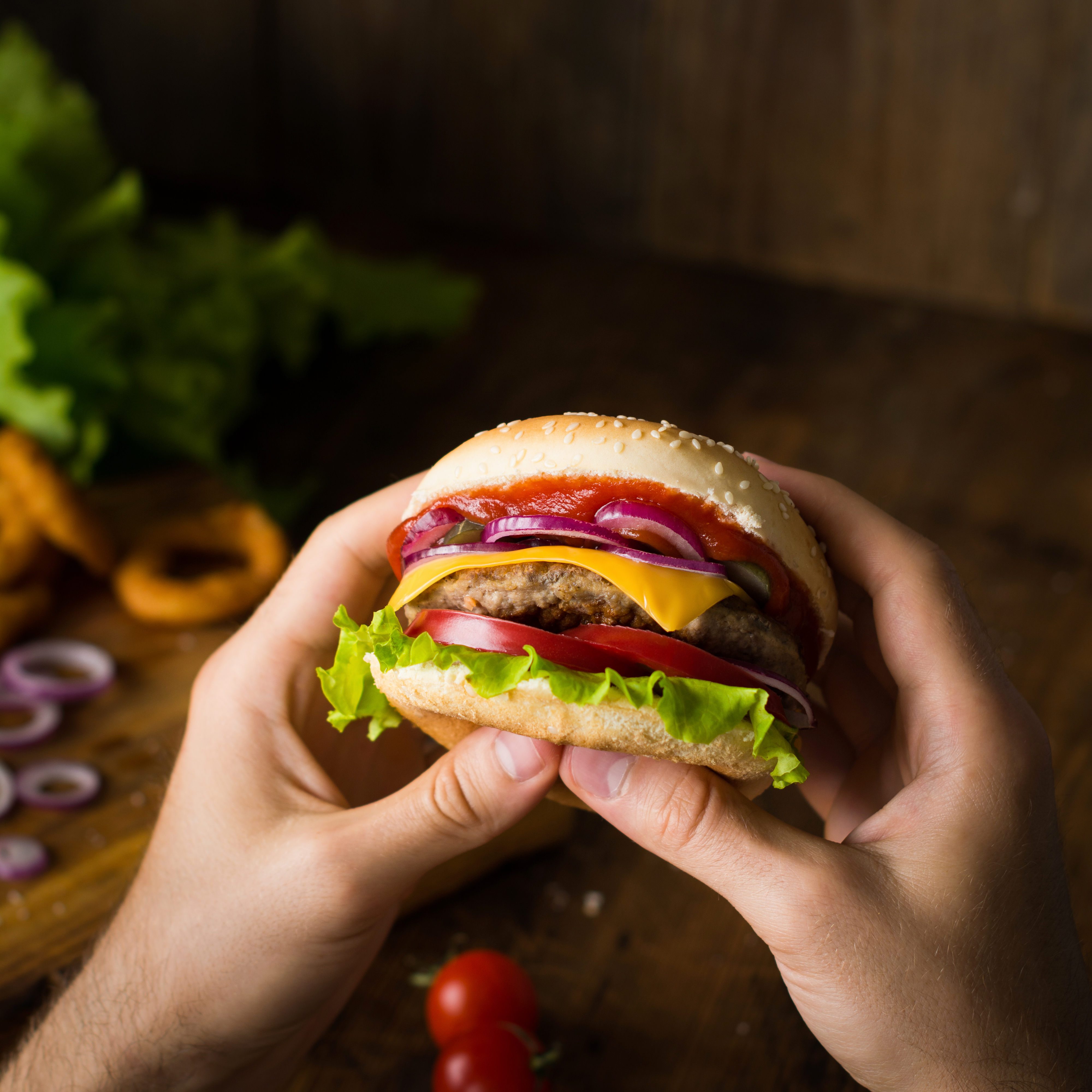 cheeseburger in hands eating cheeseburger 1111994bb49a21f7d7b6
