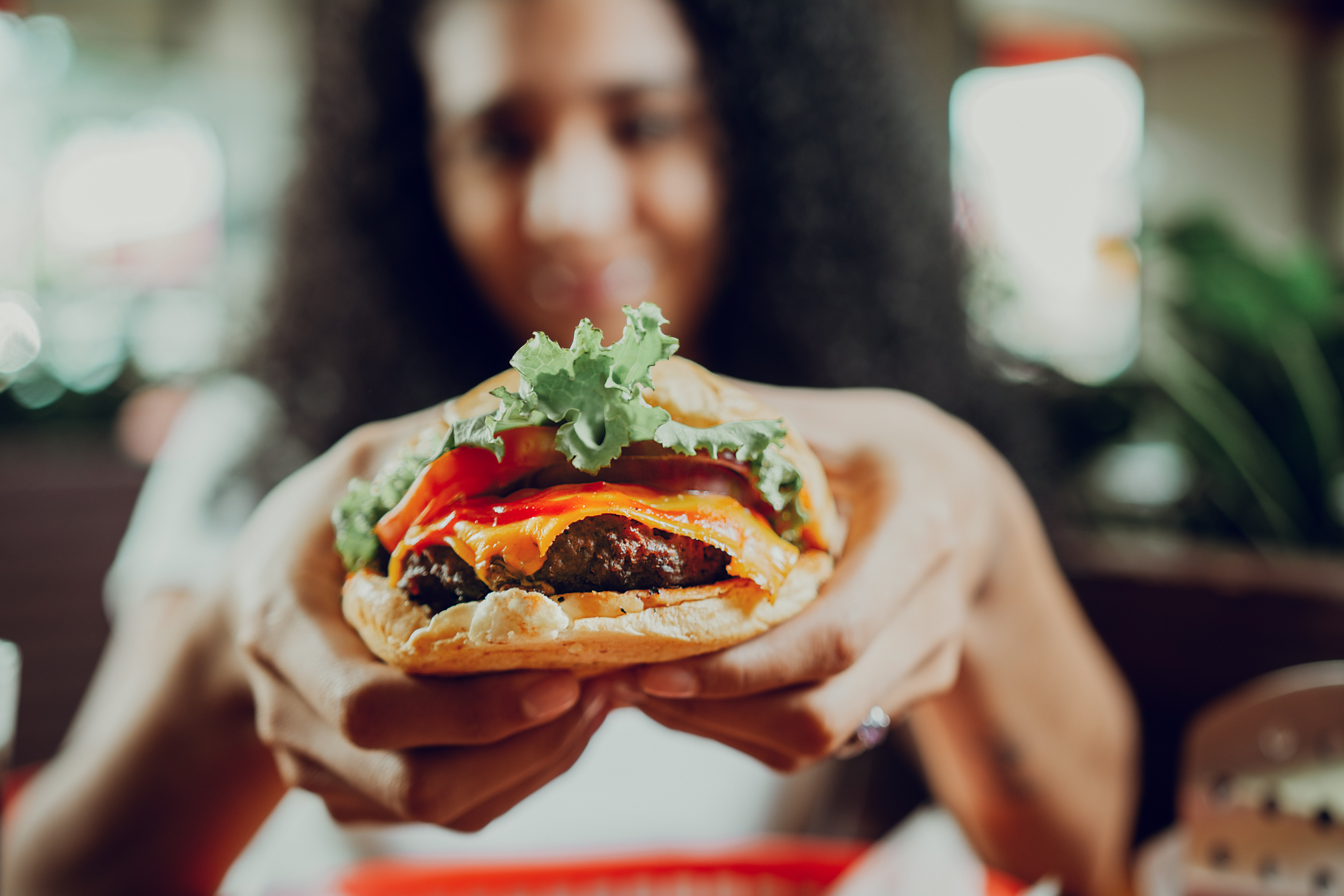 close up of a girl showing appetizing hamburger in b69e002027d782e79c28