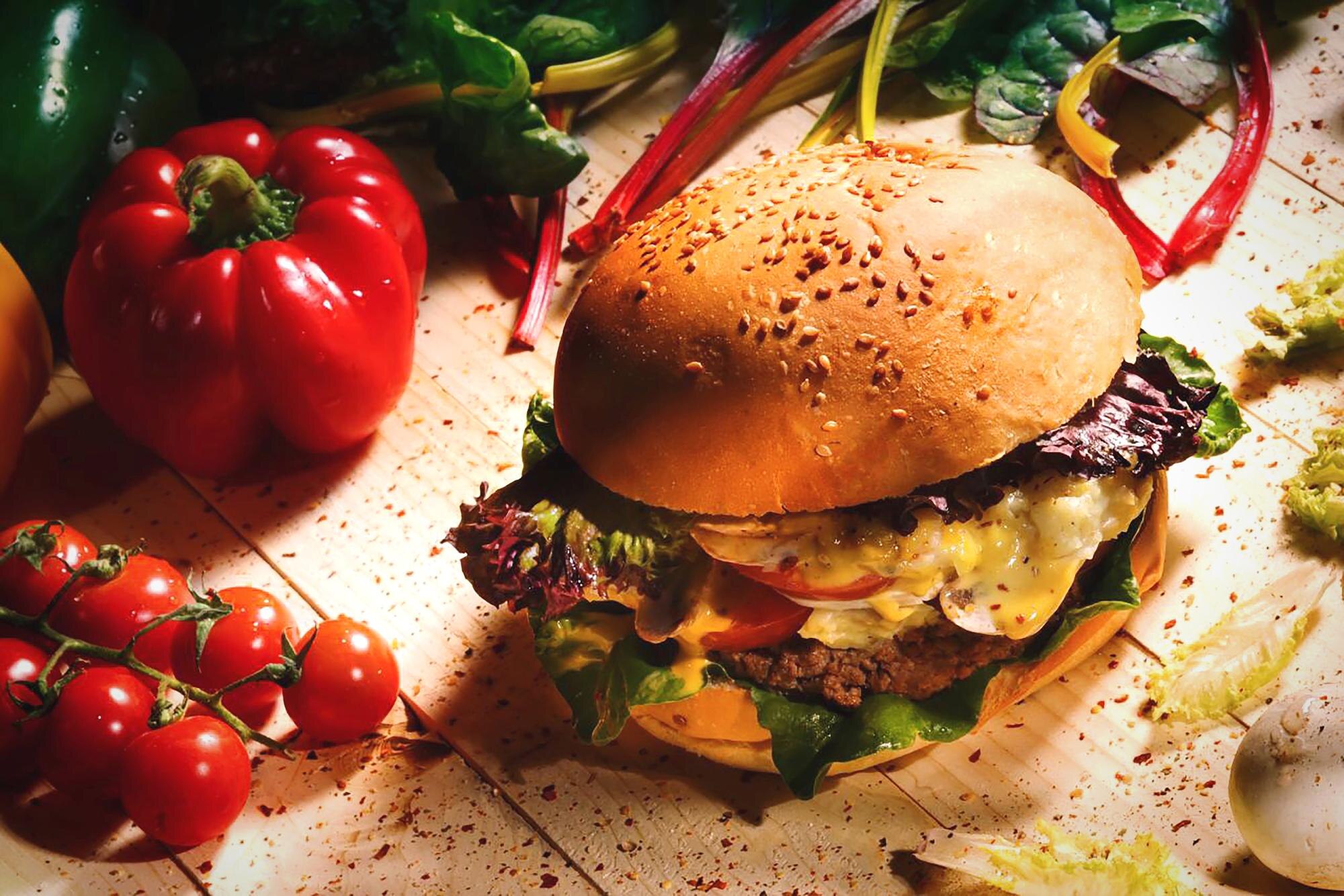 close up of hamburger and vegetables on table 5ab33a8a4088615a4650