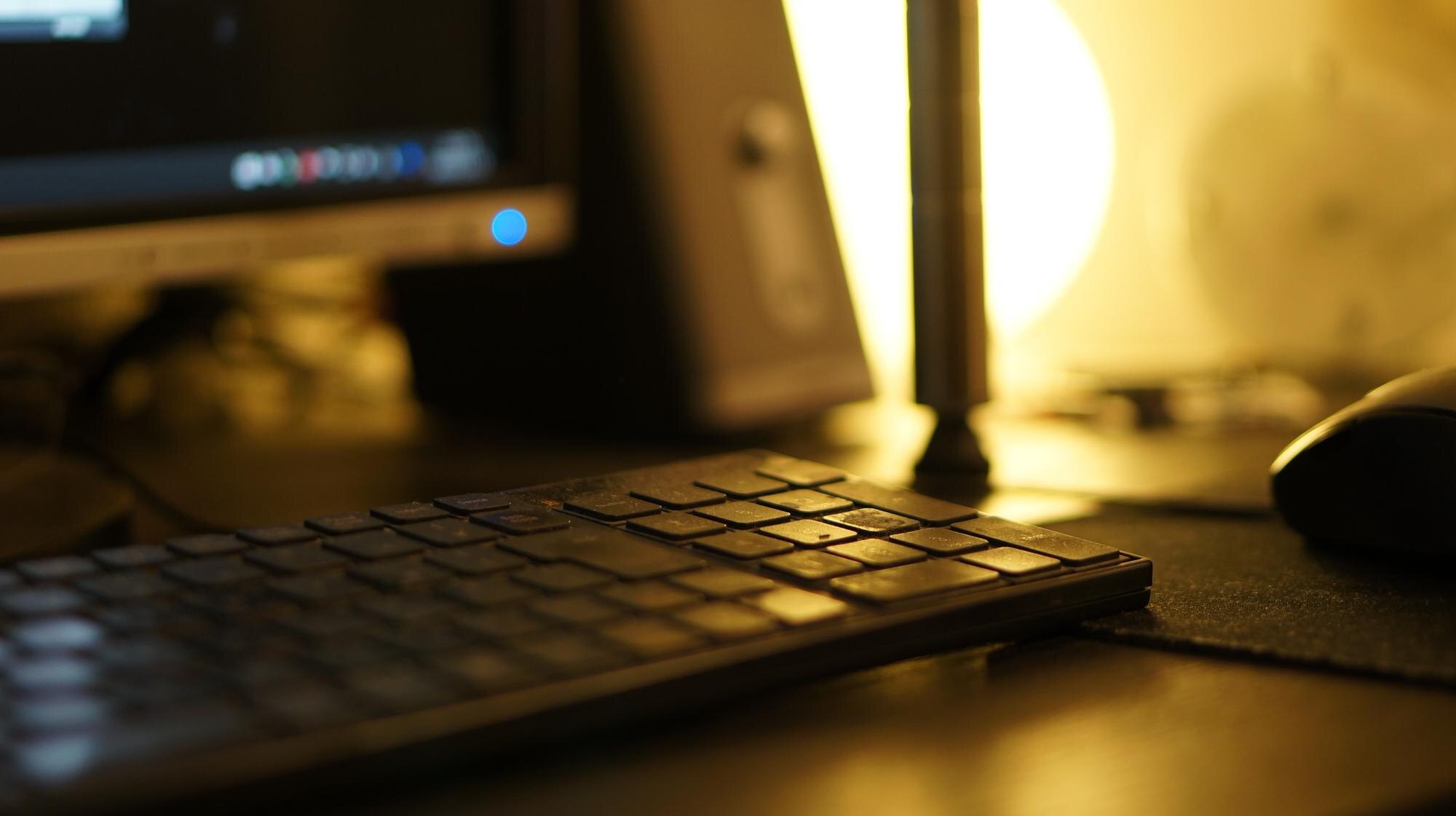A warm, focused workspace with a keyboard, mouse and monitor glowing softly, representing a productive environment for technical Seo 2026 tasks.