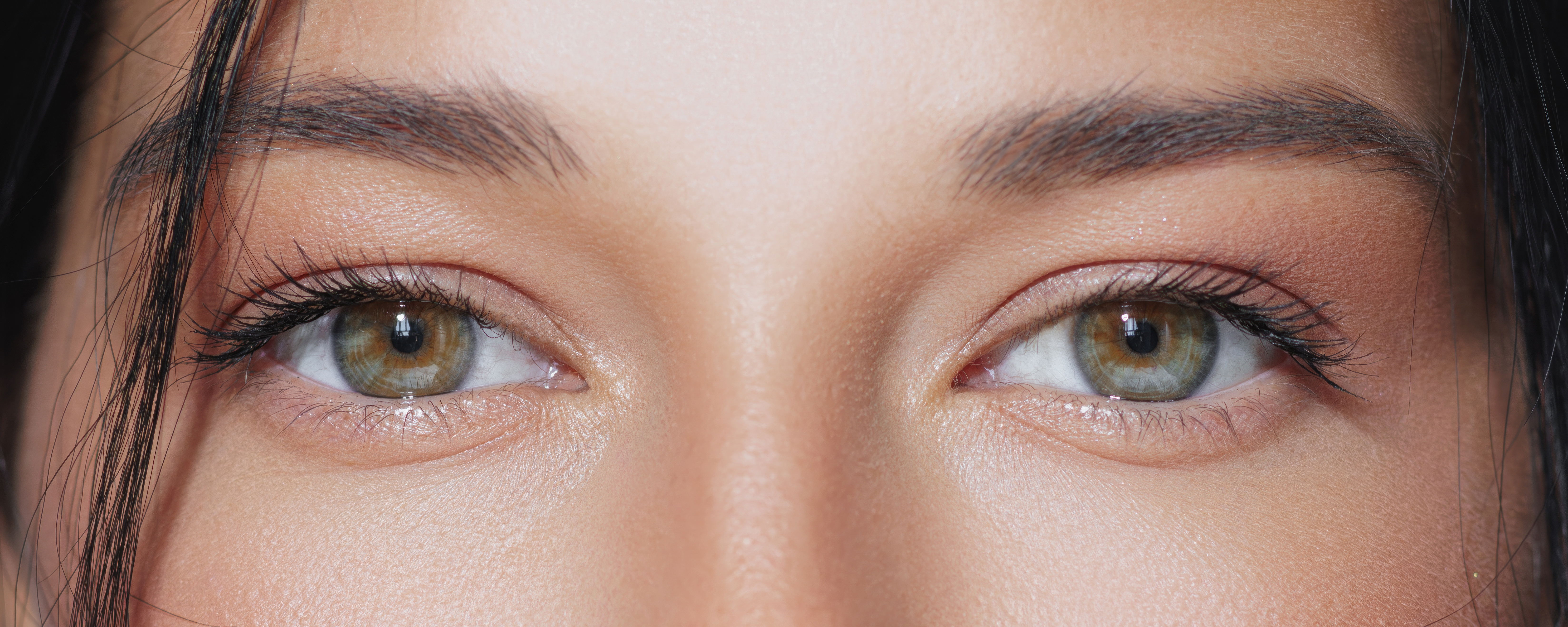 Woman applying Zyah Beauty Peptide Eye Gel-Cream under eyes for smoother, youthful skin.