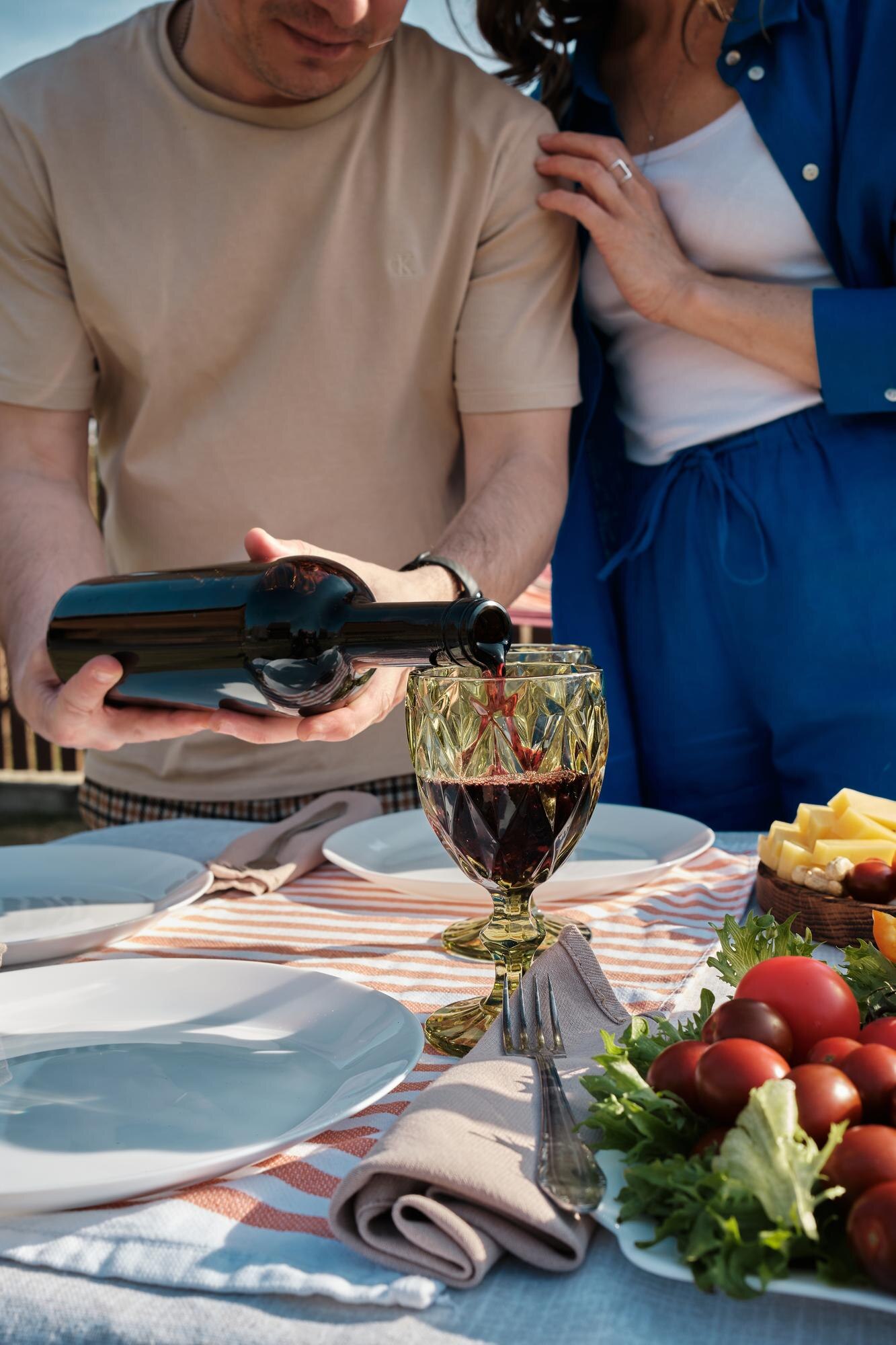 closeup of a man pouring wine into a glass for a w 7d2cf181ed1dfbeda78f