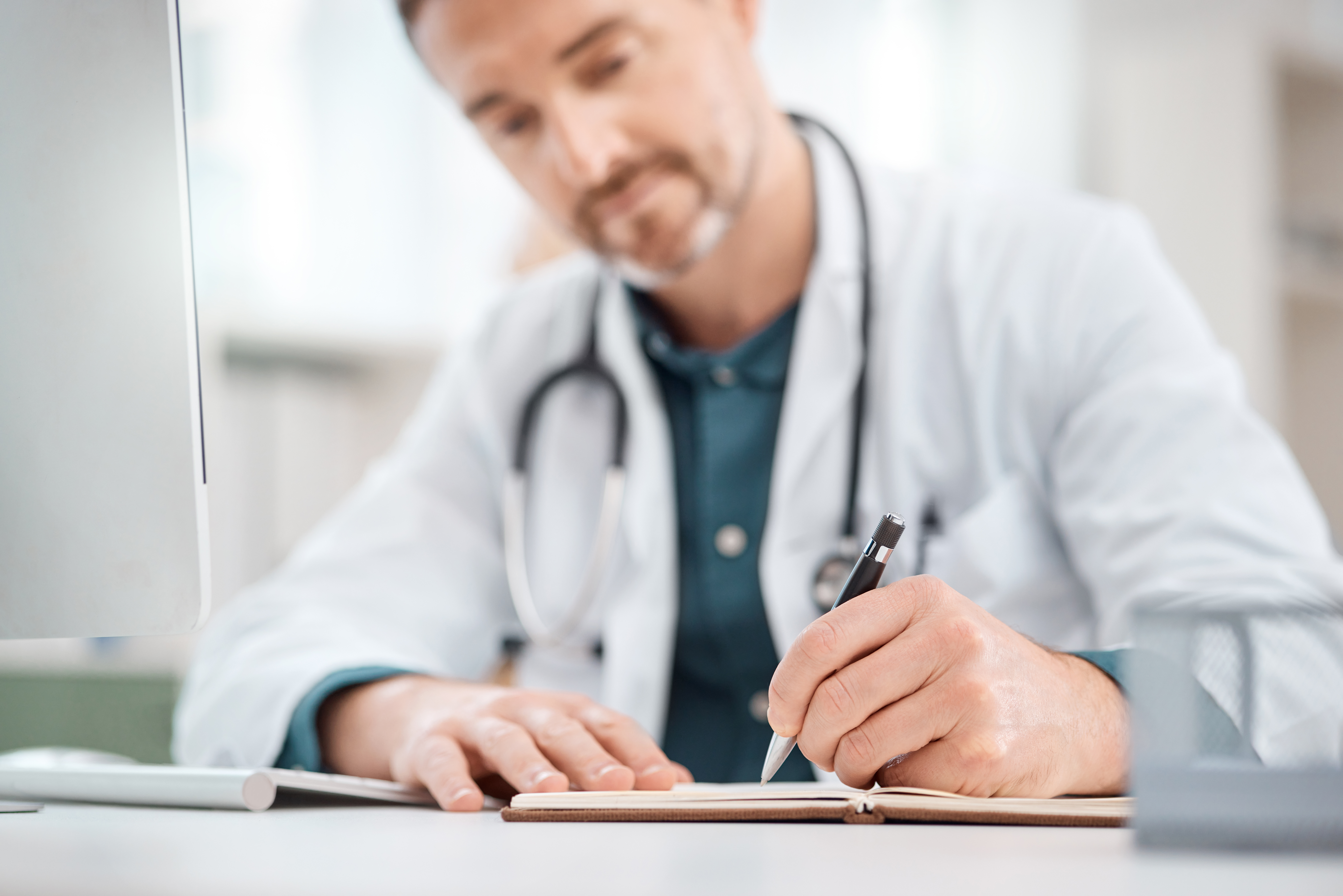 Mastering The Oet Writing Subtest: Essential Strategies Using Medical Letter Templates 2 image of a male health worker writing—an illustration of the medical letter writing course by Accordemy®
