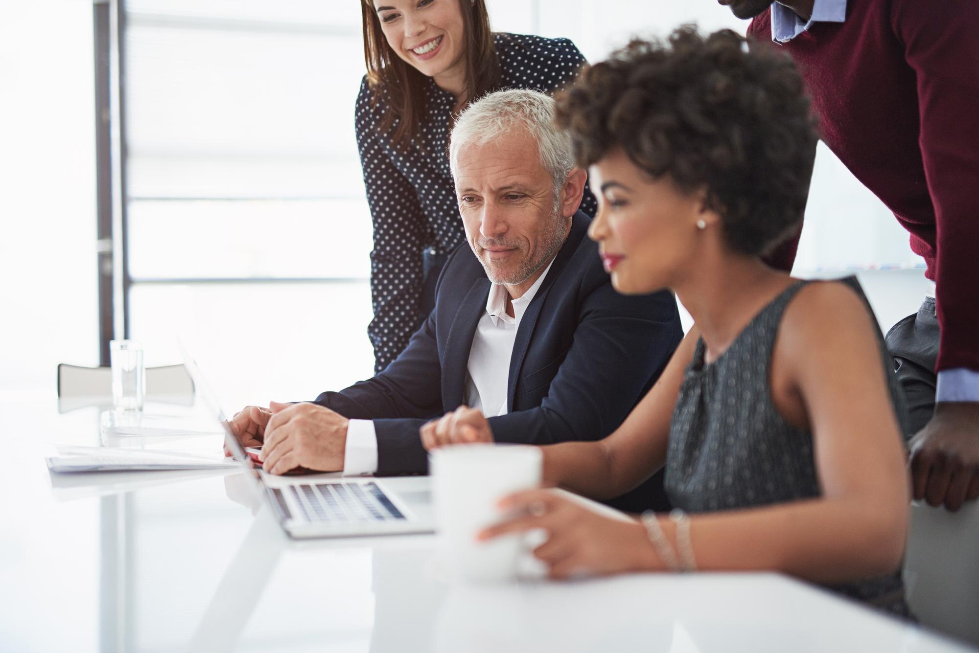 Group of professionals collaborating on estate planning strategies, analyzing documents and discussing legal guidance in a modern office setting.