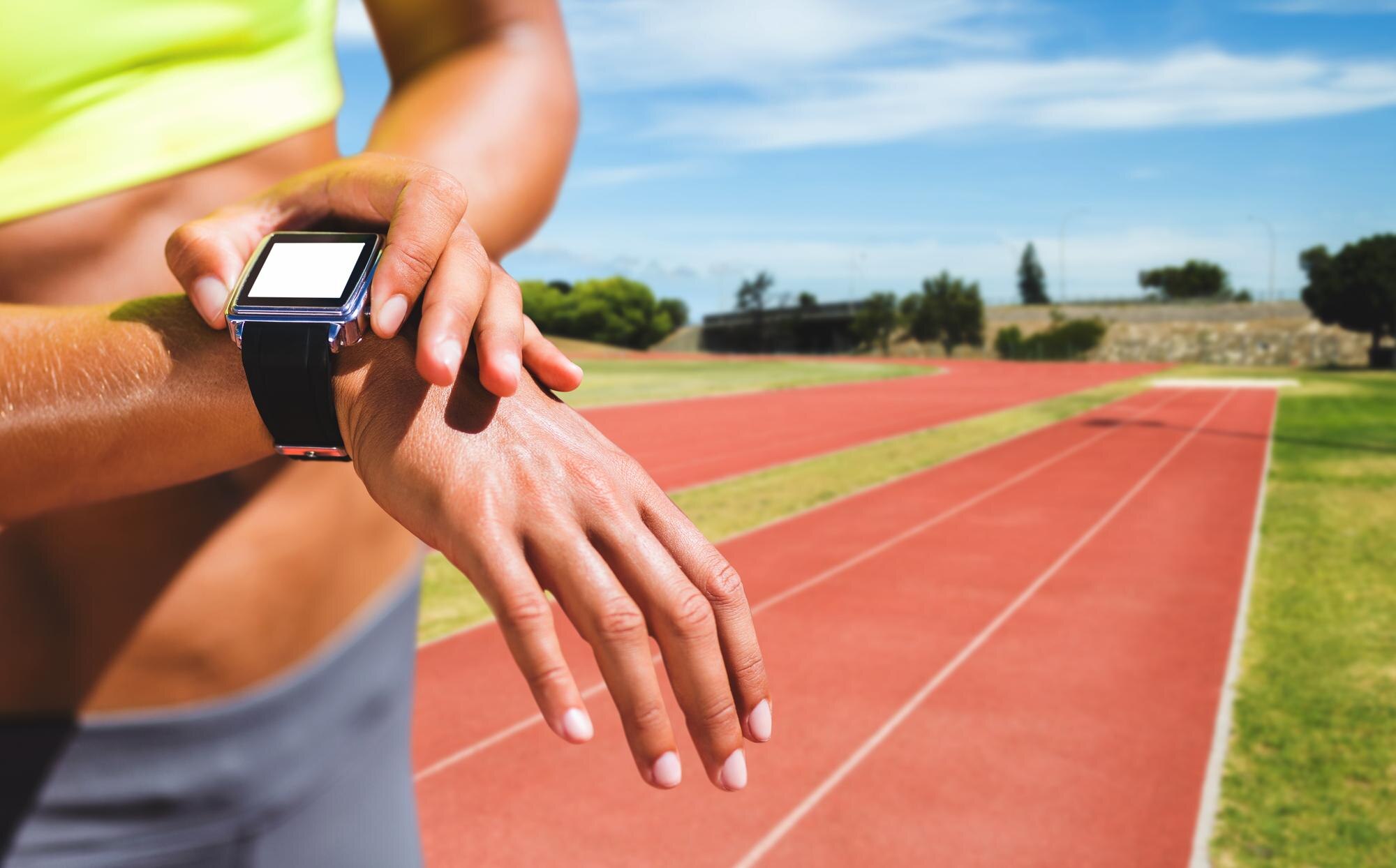 Close-up of a sportswoman checking her wearable heart rate monitor mid-run