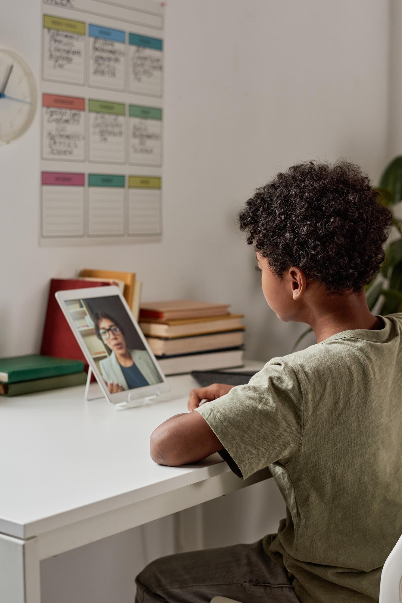 Concentrated Black Boy With Curly Hair Sitting At 4623e6683db592456f9e