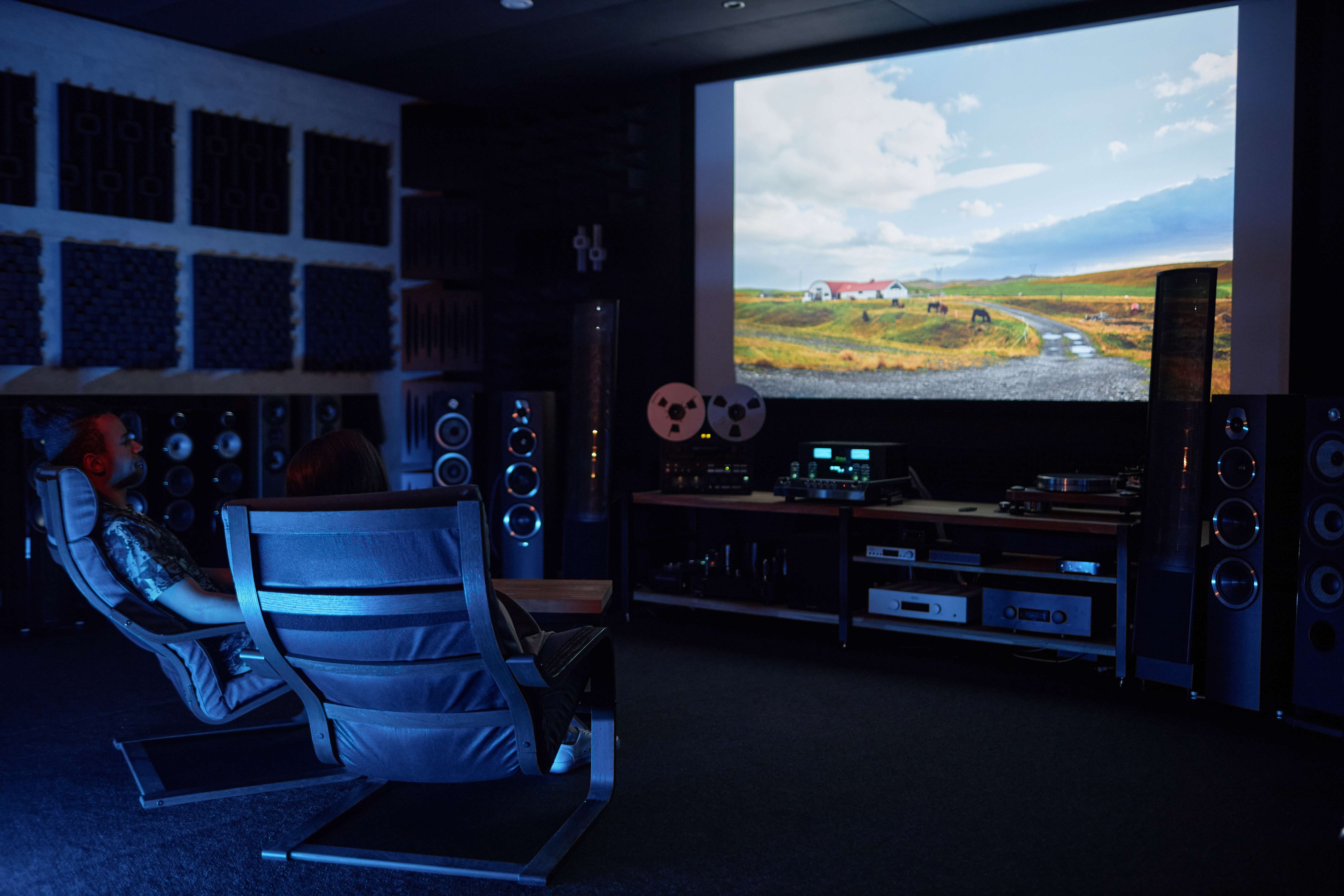couple watching movie together on big screen in ho 5dc61c6f81ab29055076