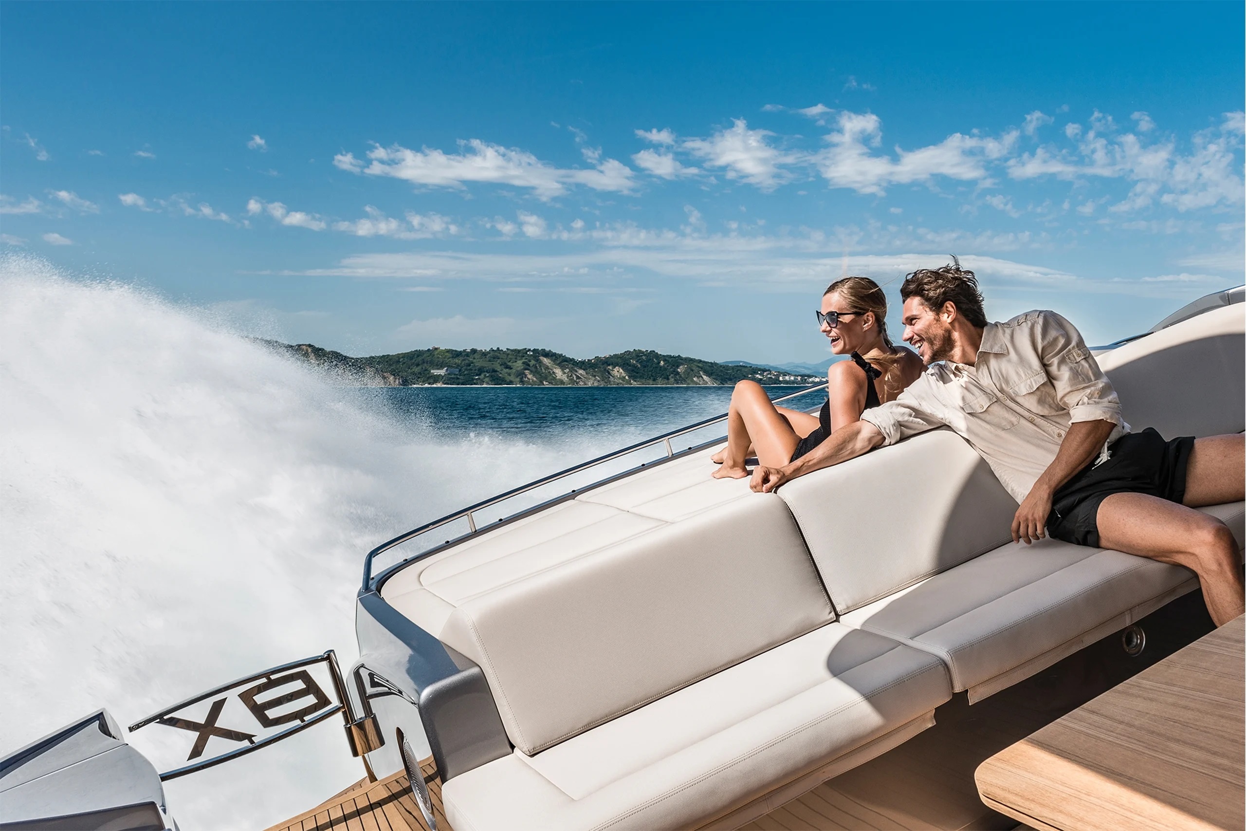 Luxury yacht anchored in a secluded cove with rugged cliffs and turquoise waters, accessible only by sea.