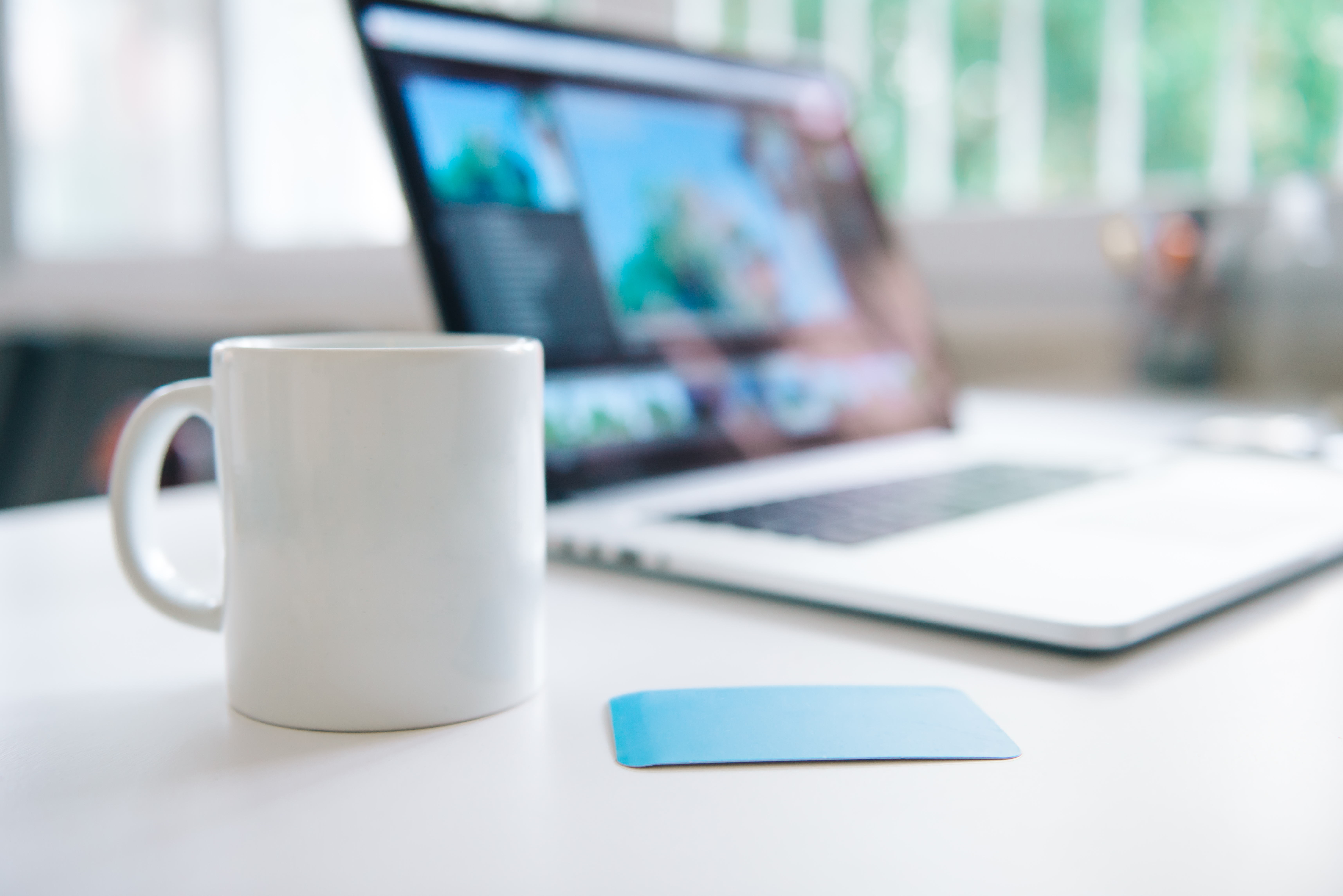 Cup of coffee beside a laptop on a table, symbolizing a productive workspace for enhancing website clarity and user engagement.