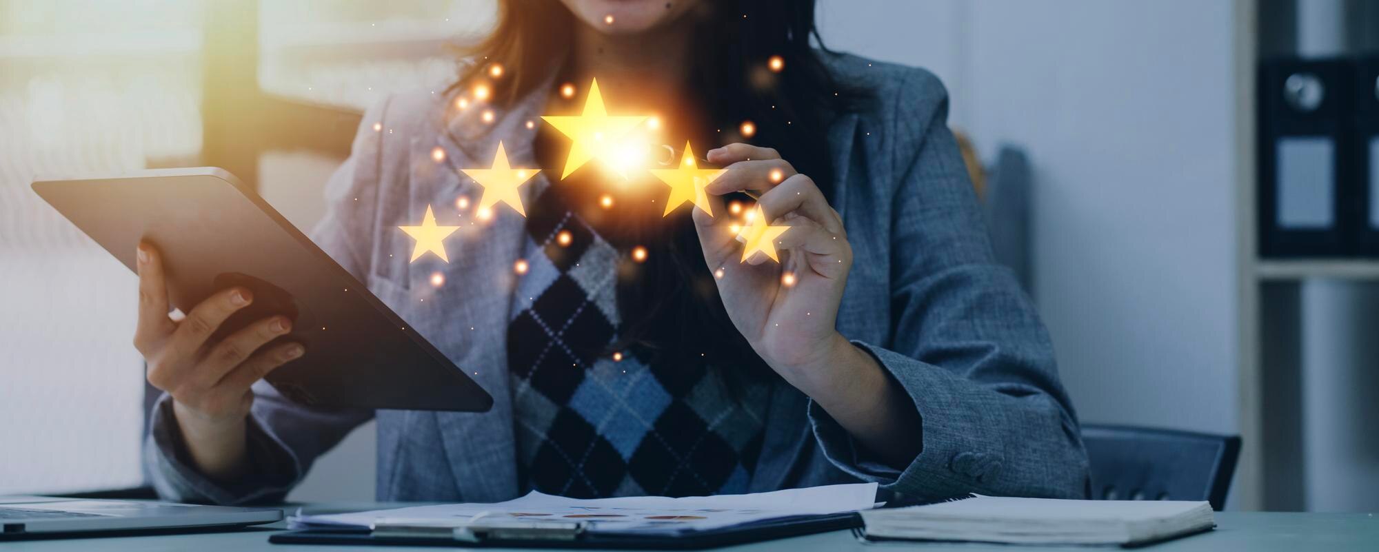 Woman in a business suit holding a tablet, displaying glowing star ratings, symbolizing customer satisfaction and online reputation management.