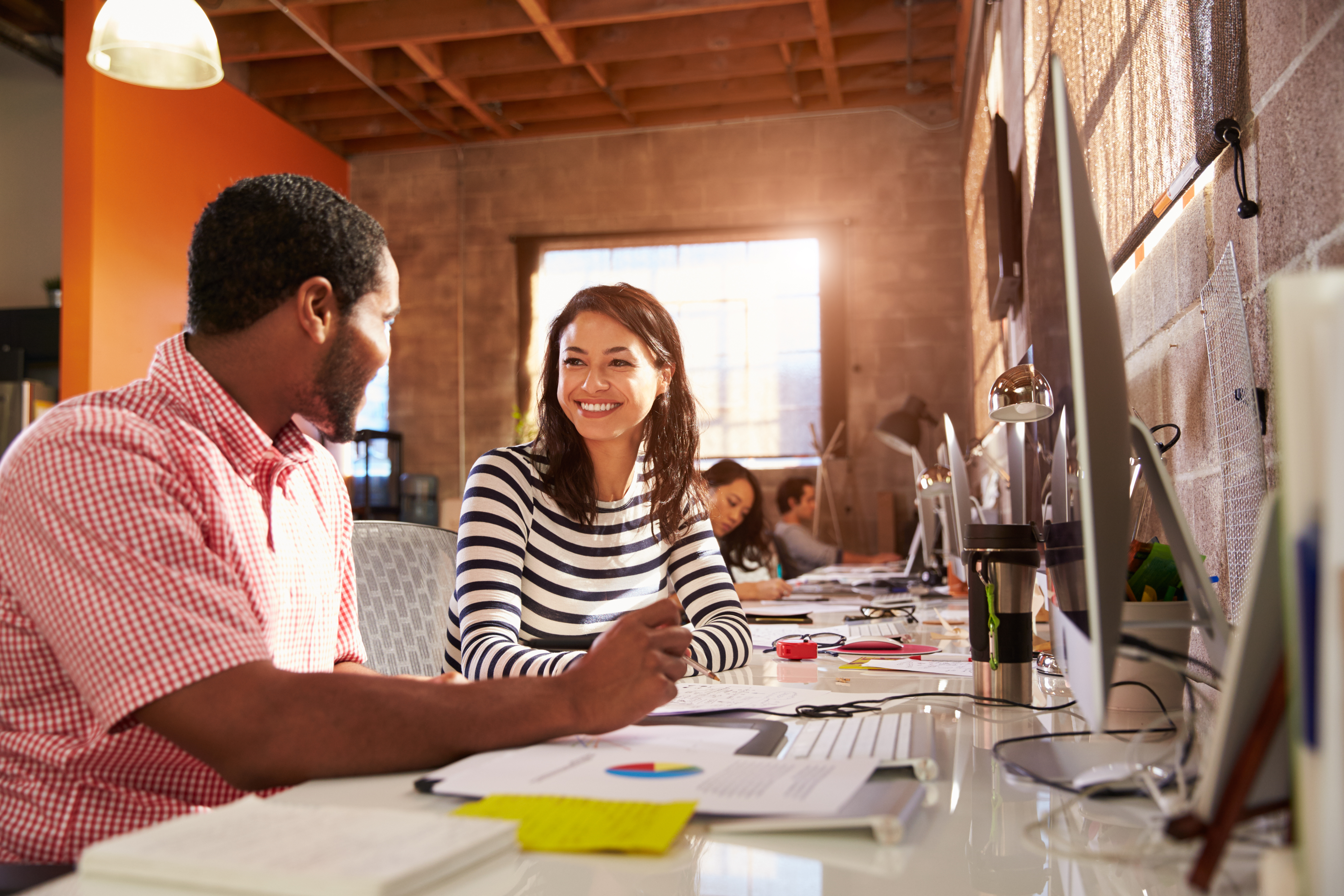 two coworkers in the office in front of their computer