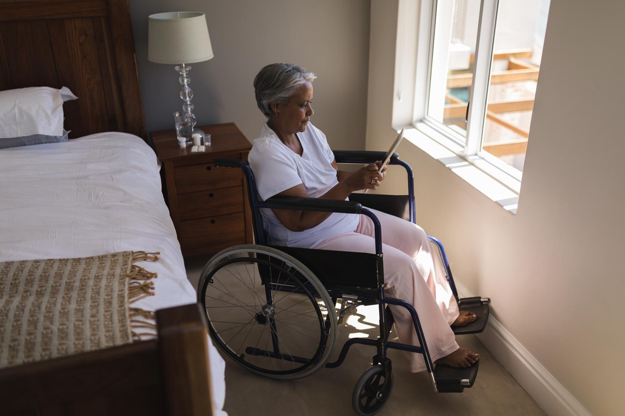 disabled senior woman using digital tablet in bedr ea1de0aa28fc7bdf976b