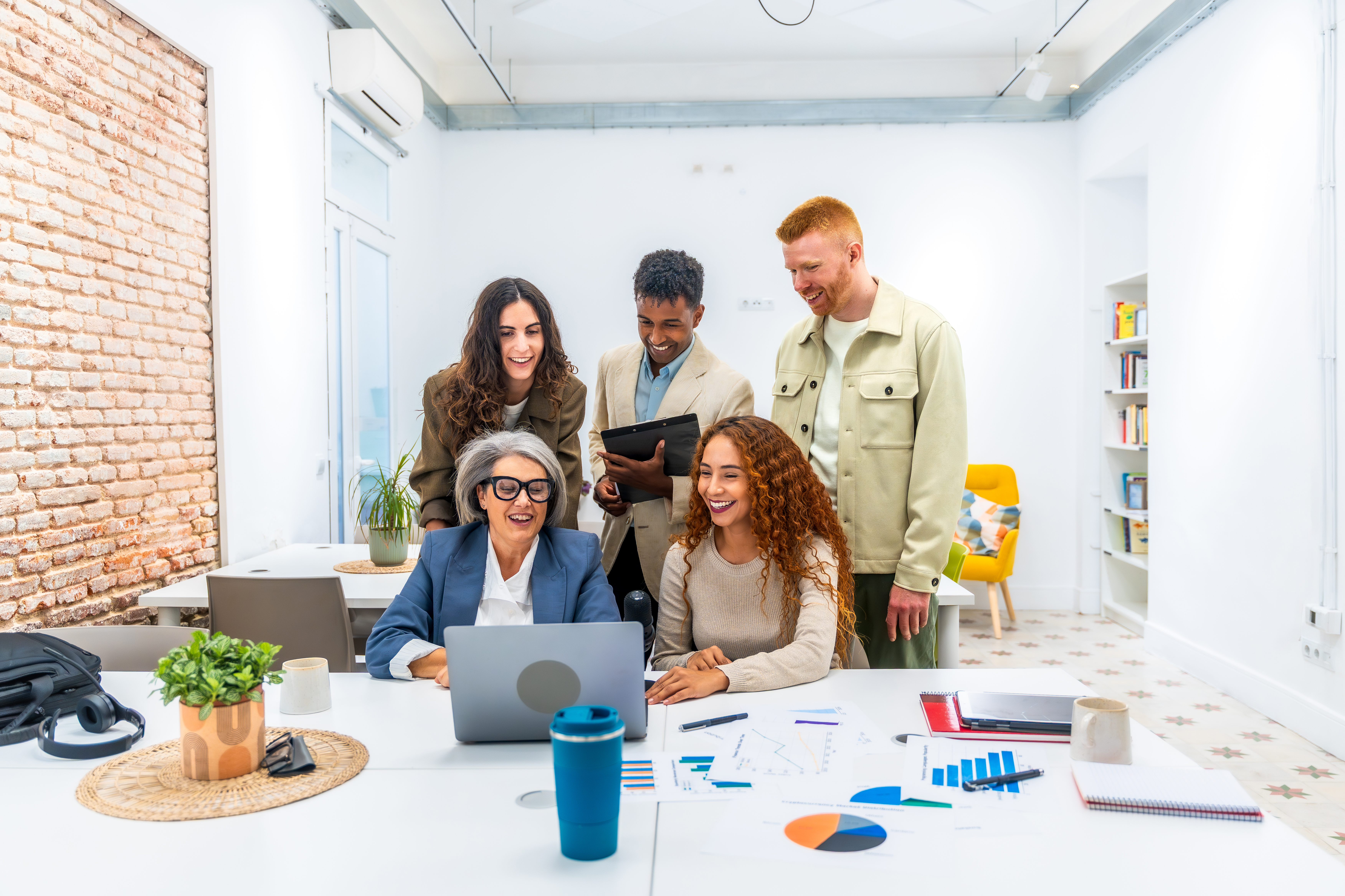coworkers collaborating in a conference room in front of a computer