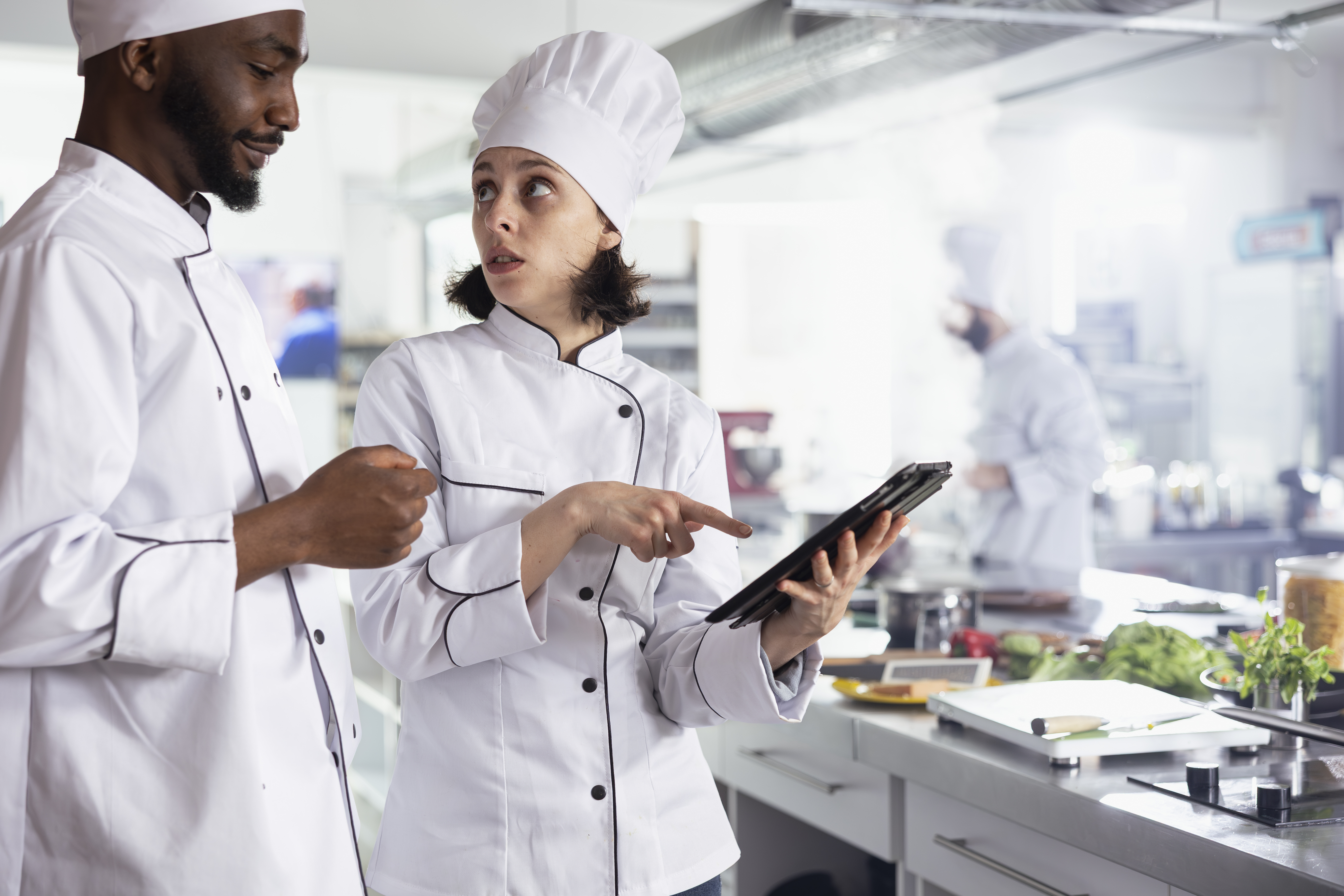 diverse_chefs_in_uniform_using_a_tablet_to_find_ne-7a589994308587762bfa.jpg