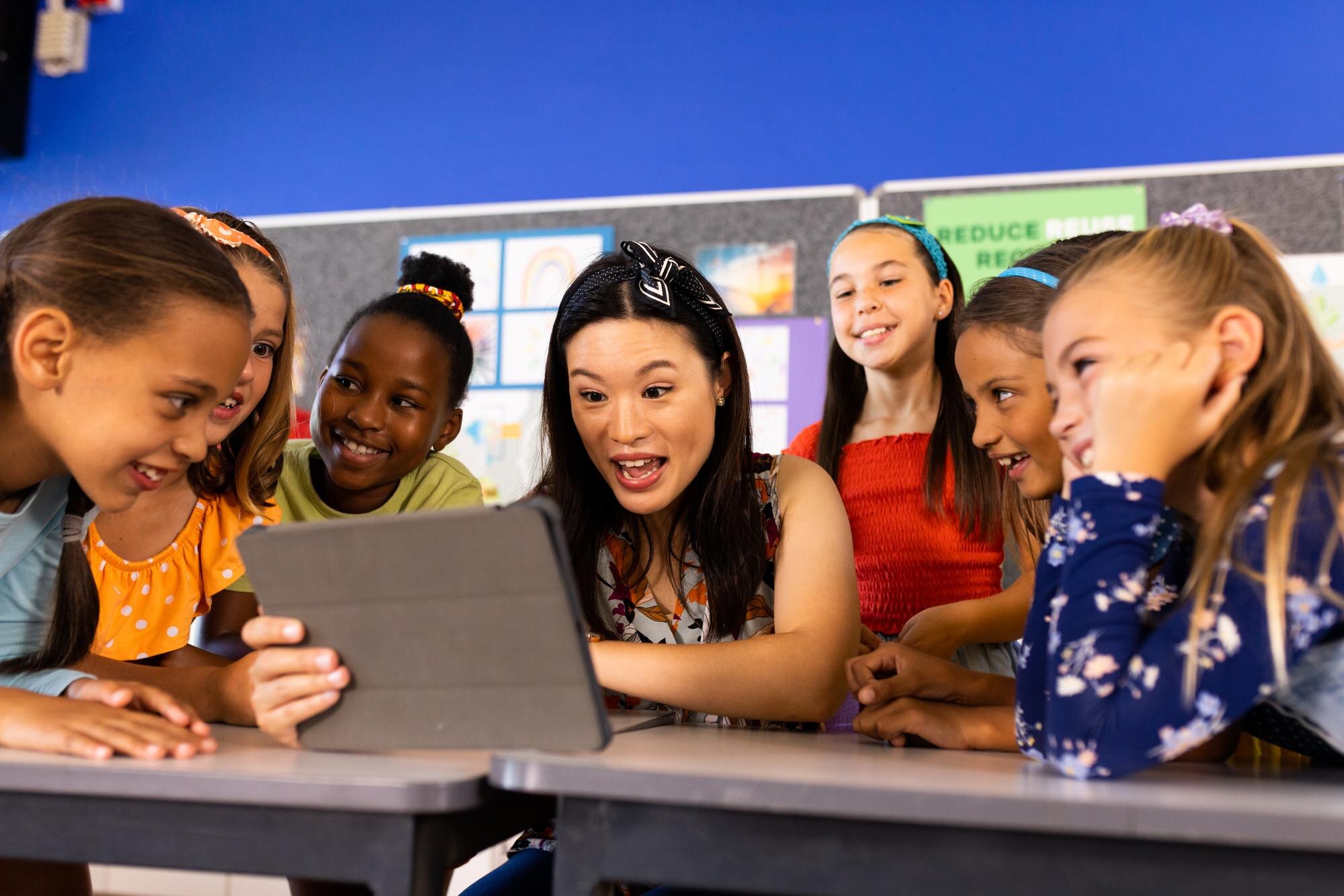 Diverse Female Teacher With Tablet And Elementary 0070447d773640bc854f