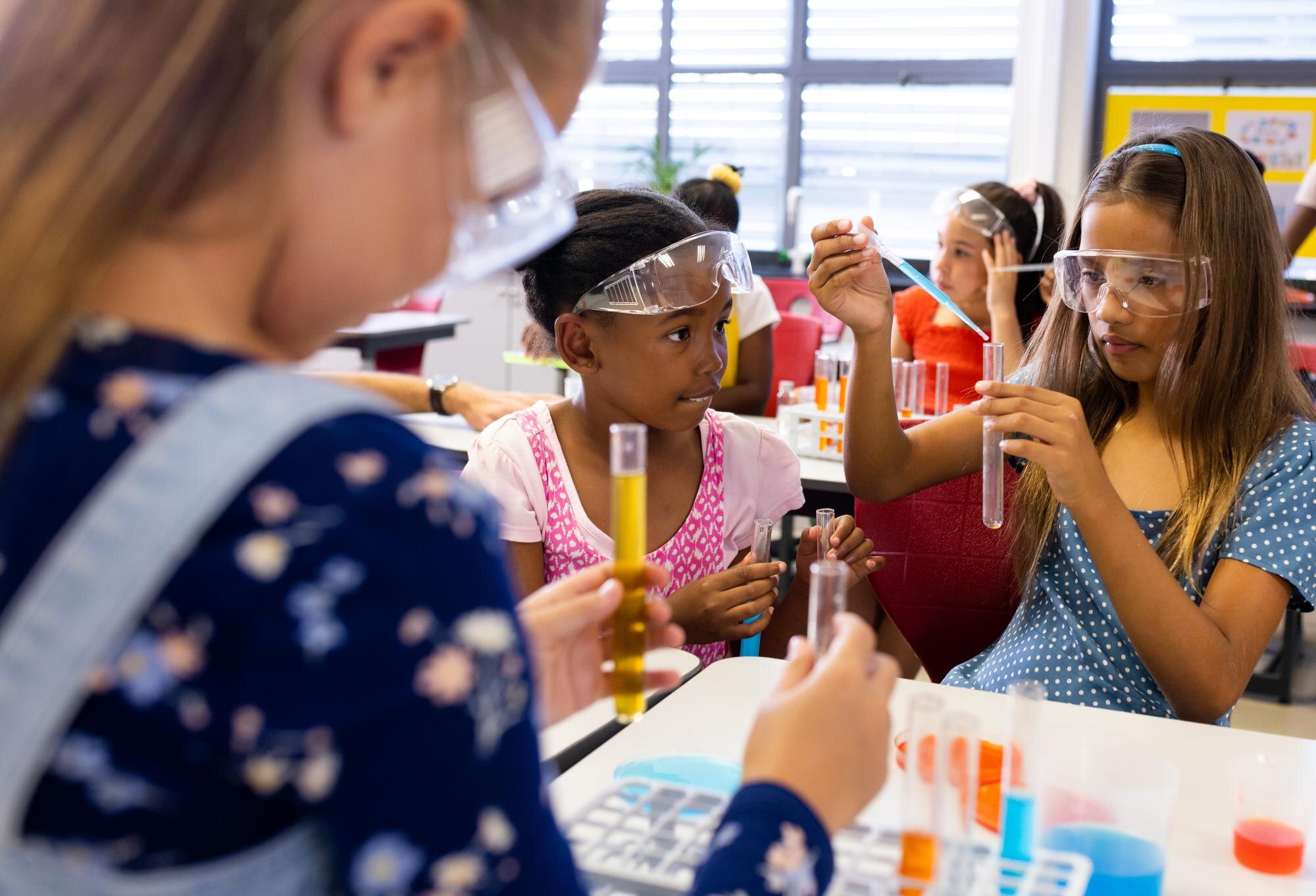 Unleashing the Power of Edutainment in Community Workshops 7 diverse schoolgirls with chemistry items and liqui 62e84c0f9516b0514ad3