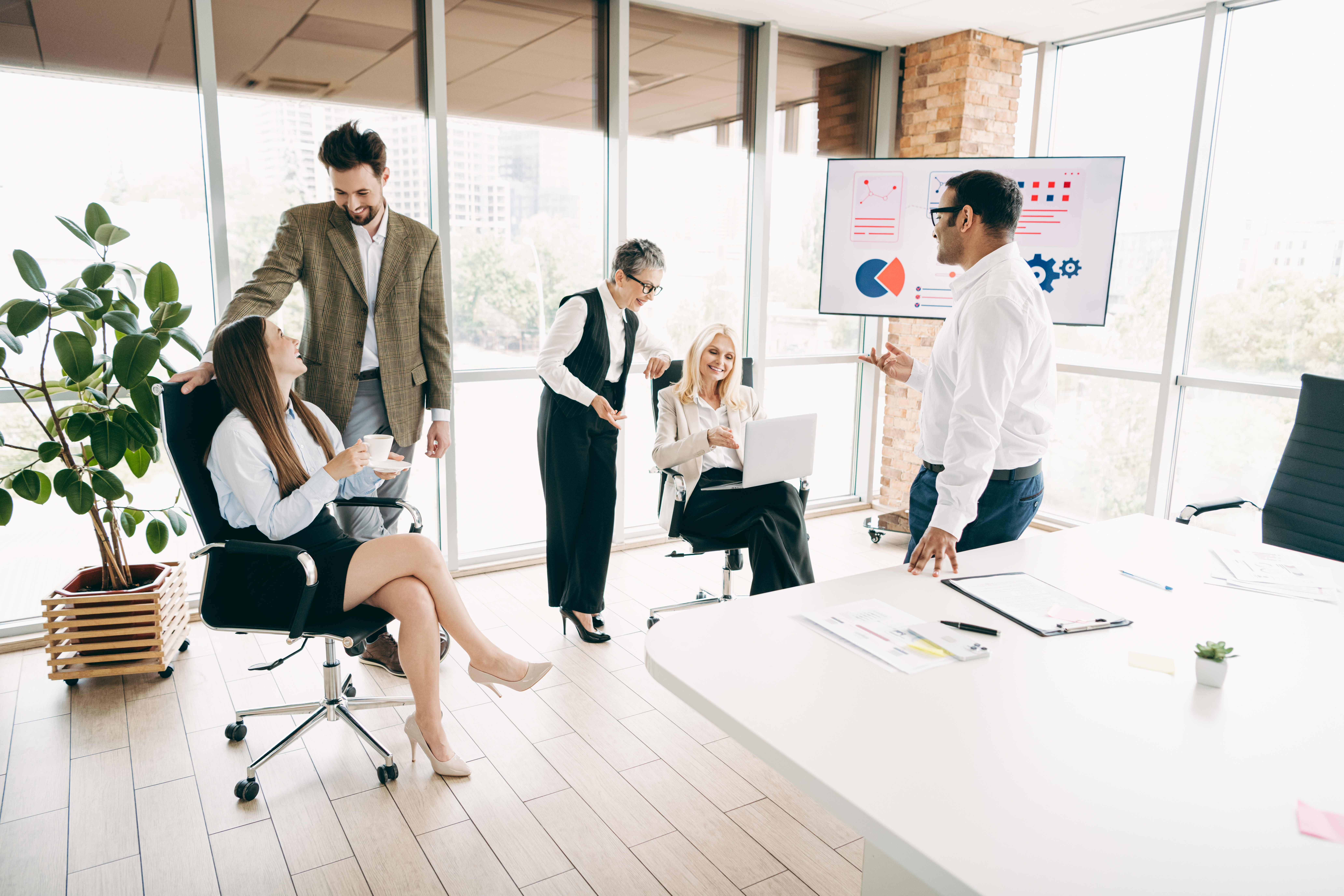 Diverse team collaborating in a modern office, discussing data-driven metrics for local SEO strategies, with charts displayed on a screen.