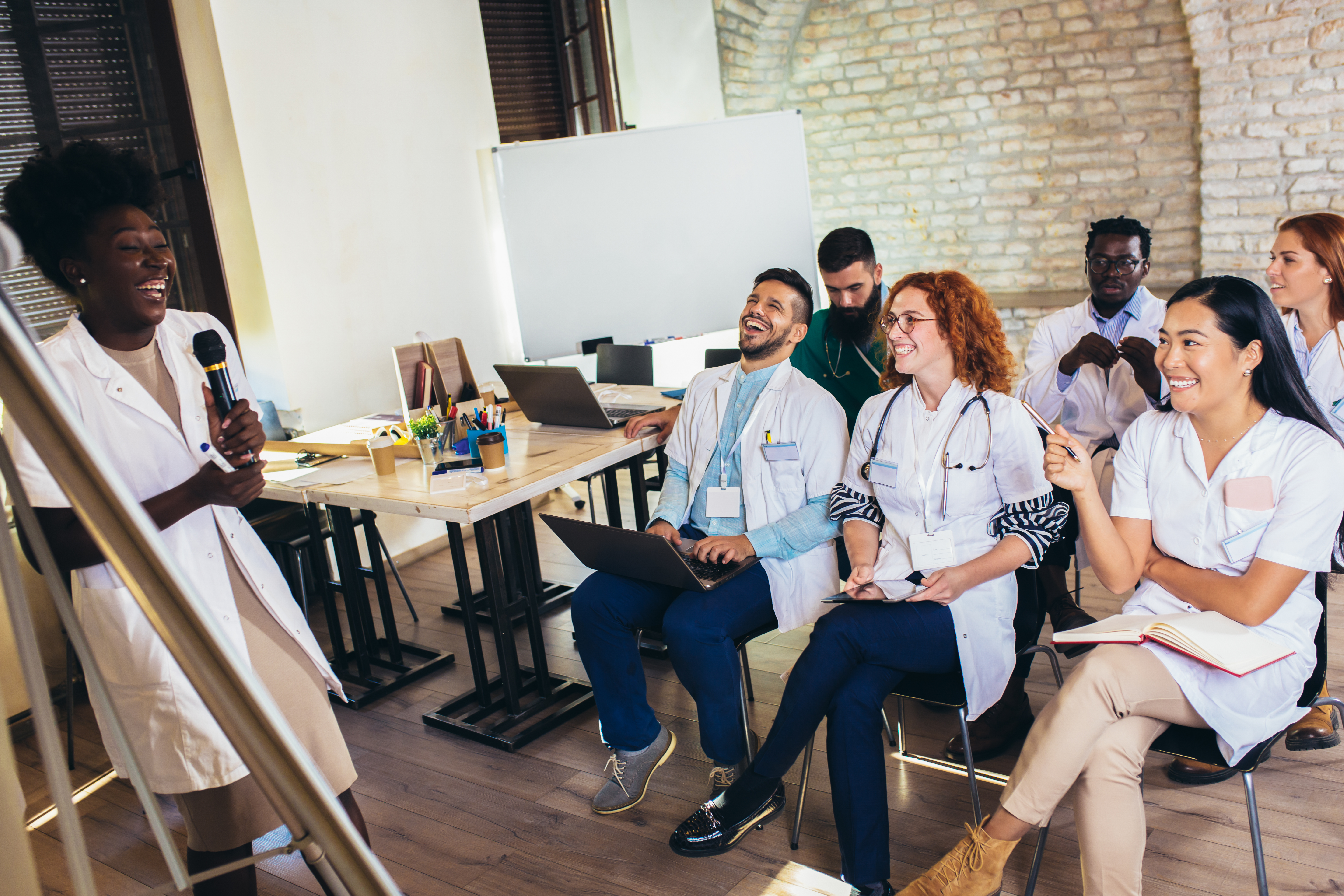 Unlocking Success: The Power Of Expert-Led Oet Preparation For International Medical Graduates 3 image of medical workers listening to a colleague presenter to illustrate OET preparation courses by Accordemy® - #The best OET preparation course