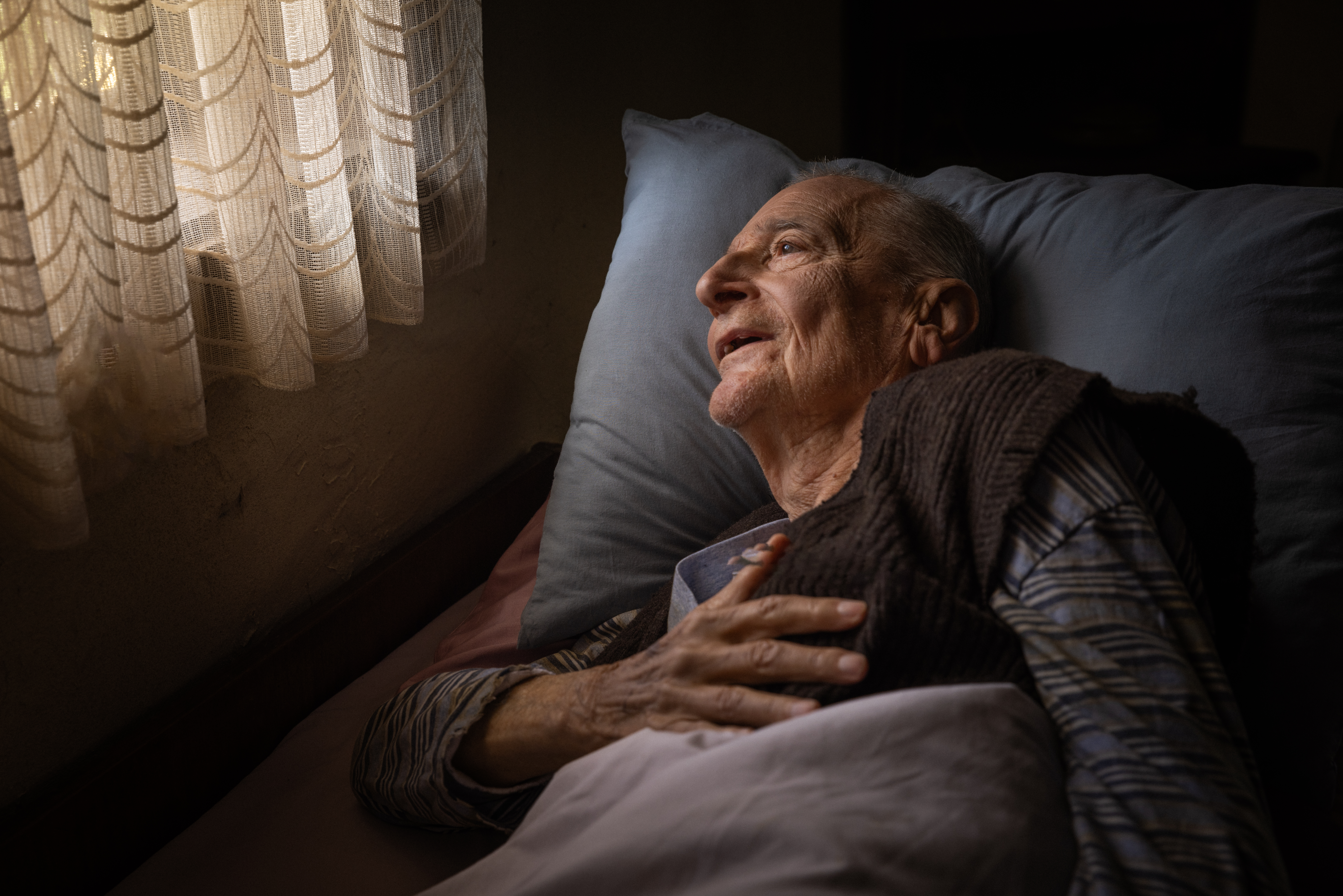 elderly man lying in bed with a serene expression 0e29a2d196d0b824d419